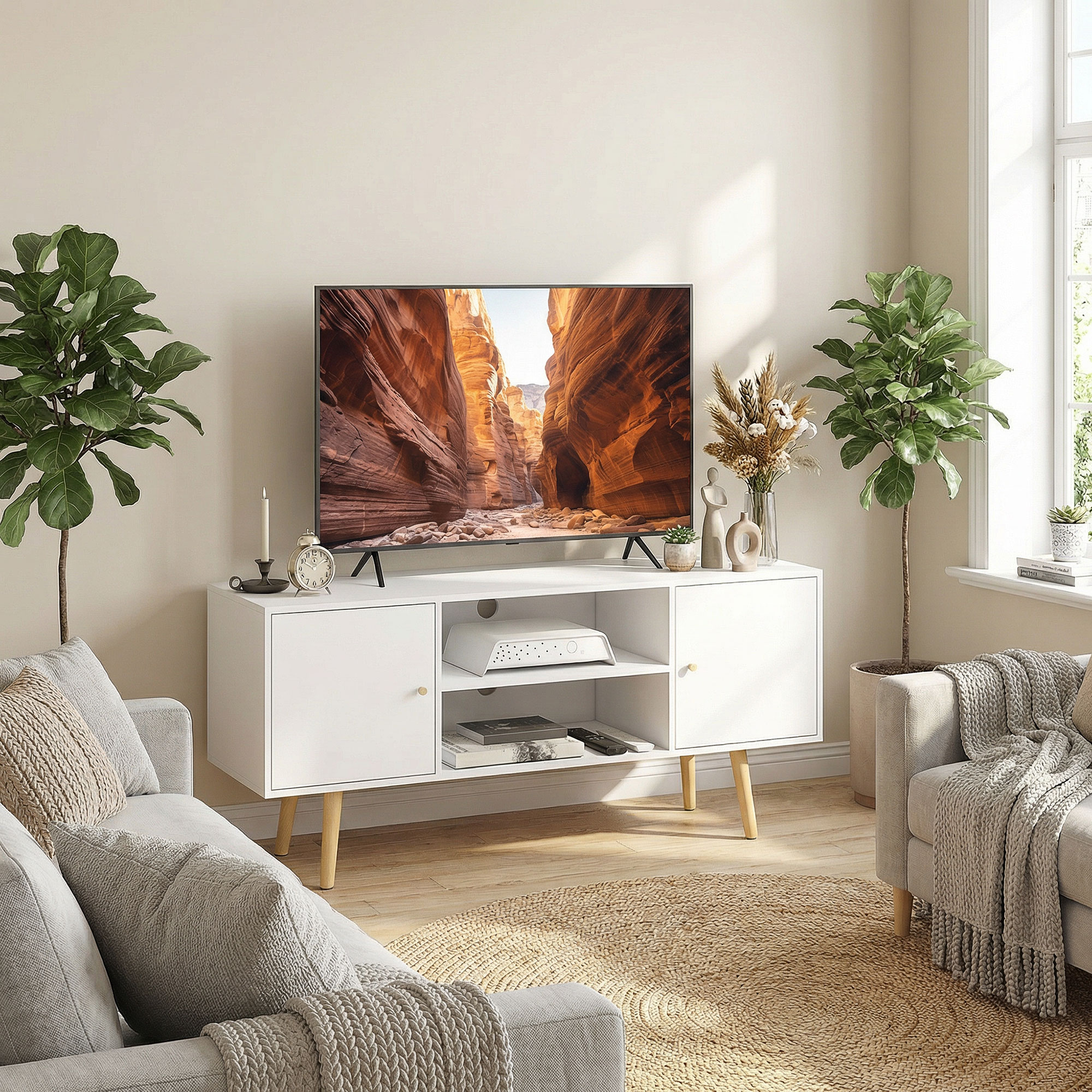 Una sala de estar luminosa con un mueble de TV blanco, sofás y plantas.