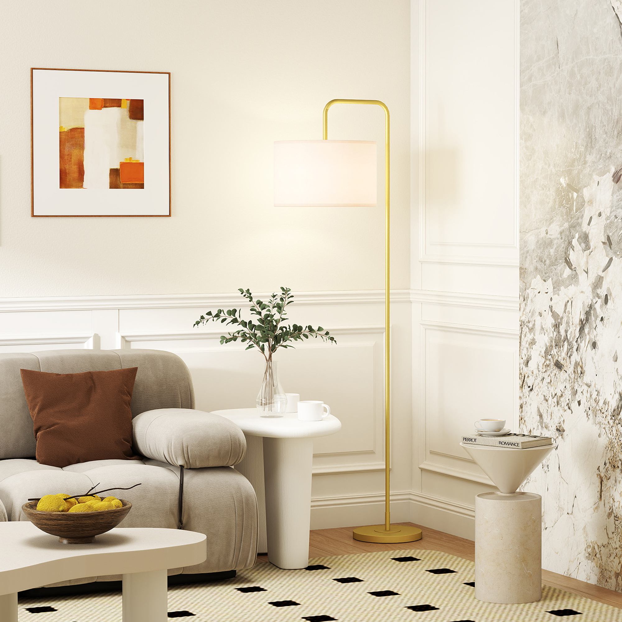 Una sala de estar con sofá, mesa de centro, lámpara de pie y arte en la pared.