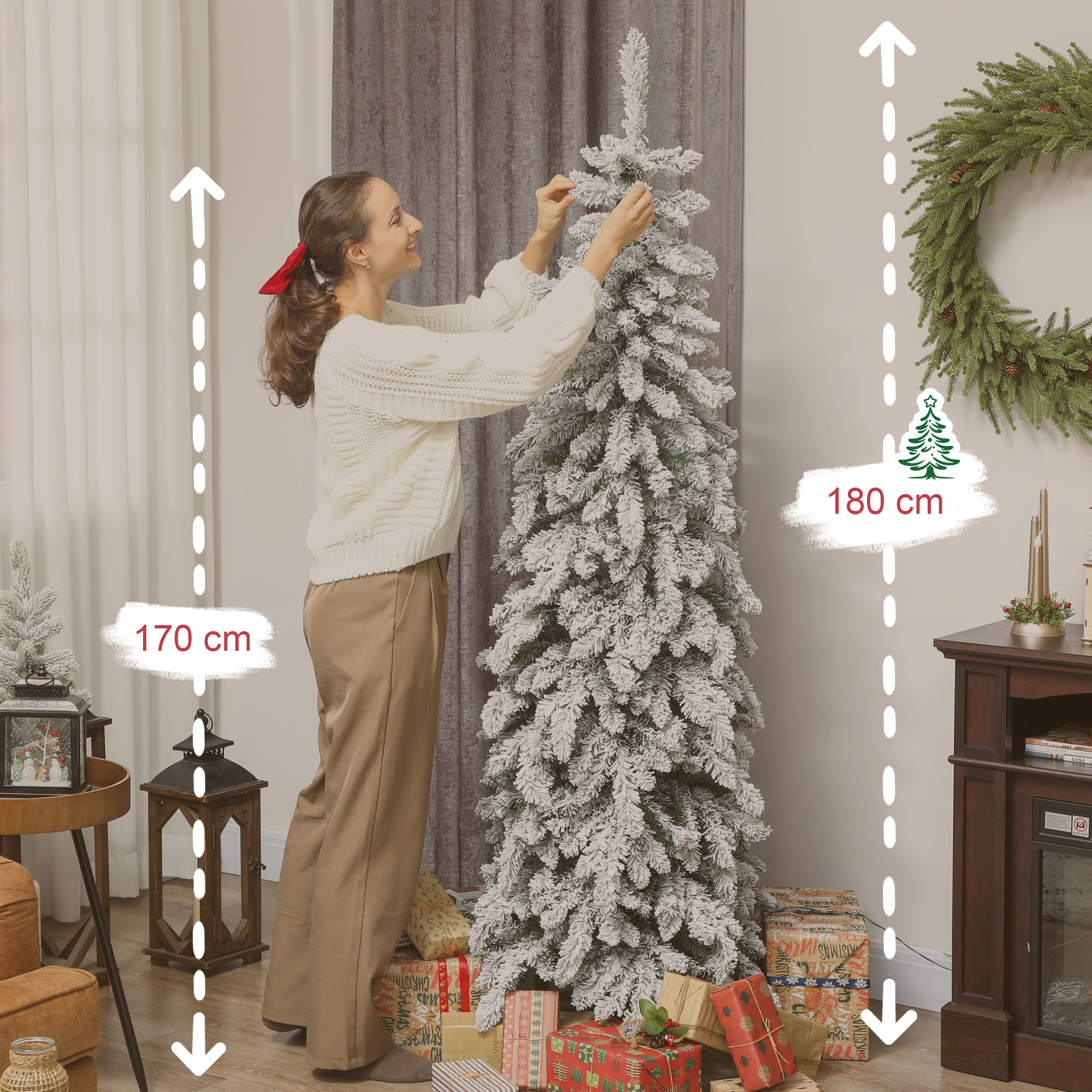 Una mujer decora un árbol de Navidad nevado. Regalos en la base.