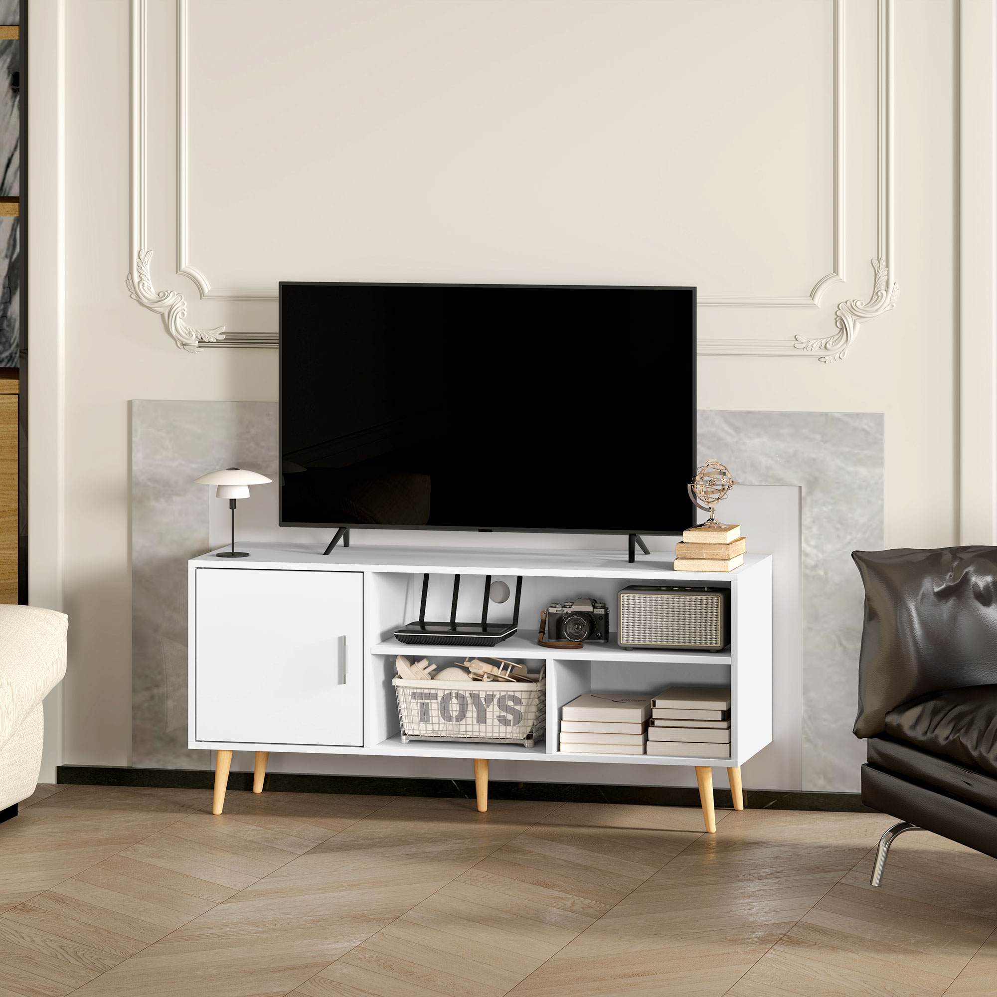 Un mueble de TV blanco con TV, lámpara, radio y libros.