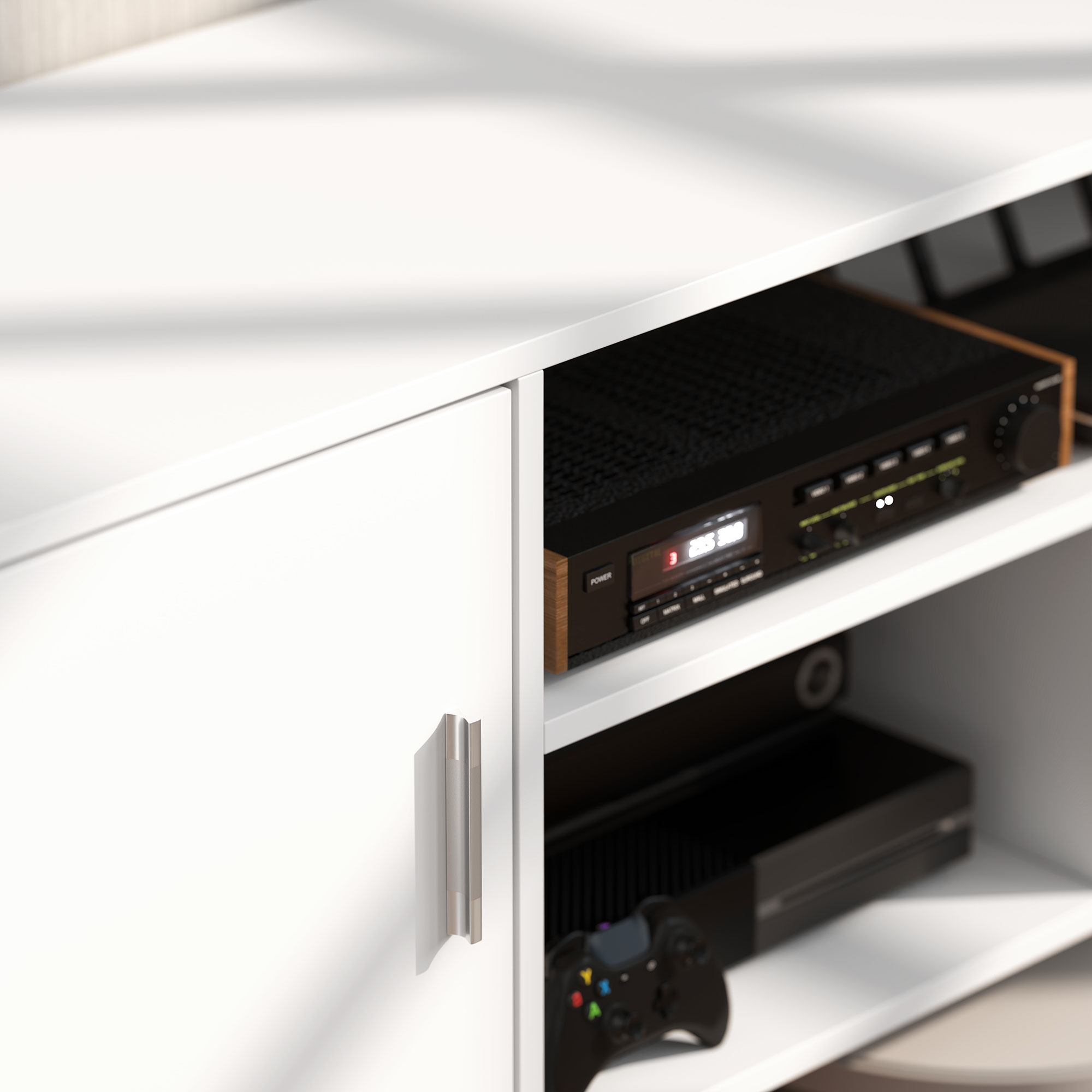 Un receptor negro y una consola de juegos en un mueble blanco.