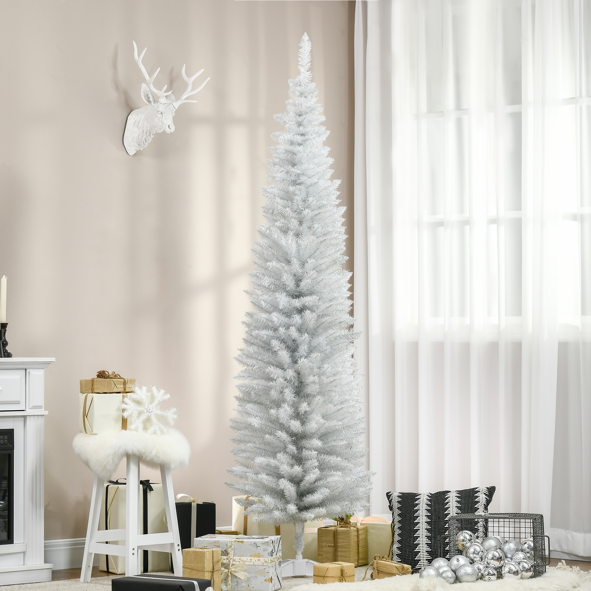 Un árbol de Navidad blanco se alza con regalos y decoraciones en la sala.