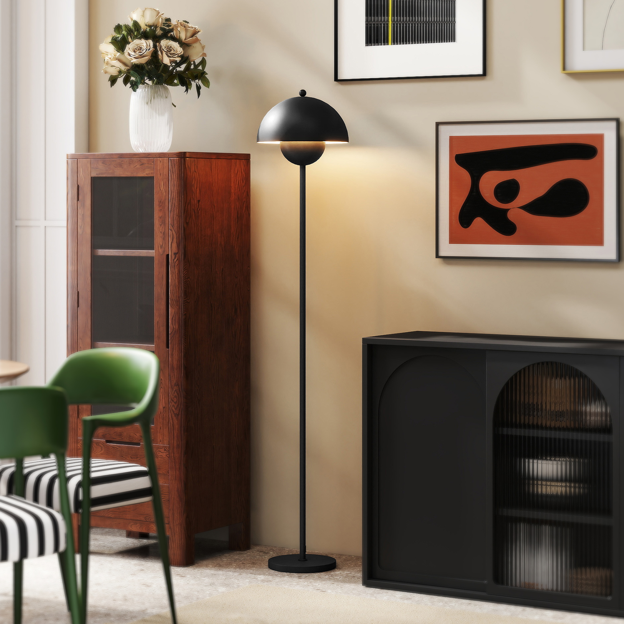 Una sala de estar con mueble de madera, lámpara de pie negra, sillas verdes y arte en la pared.