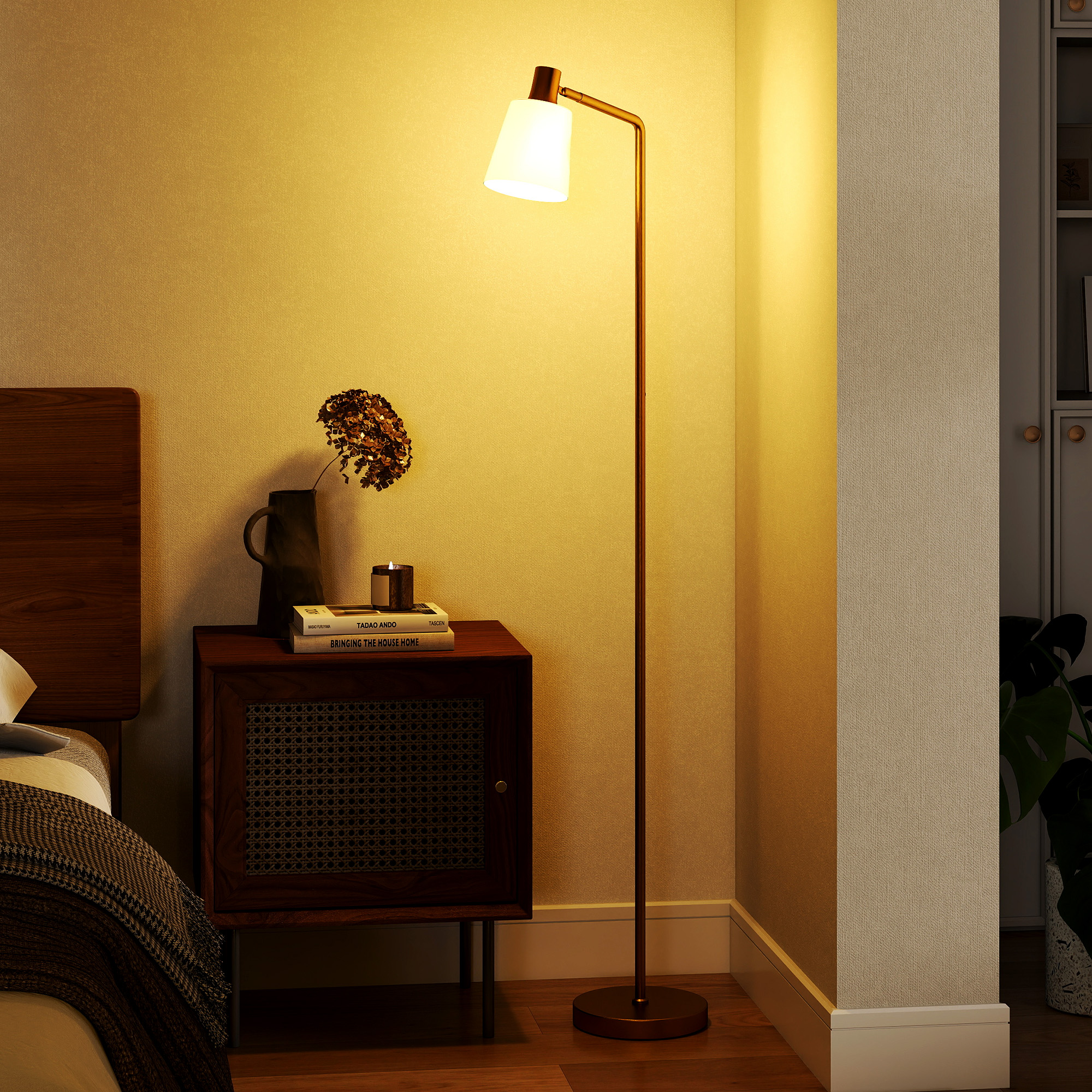 Una mesita de noche de madera junto a una cama, iluminada por una lámpara de pie.