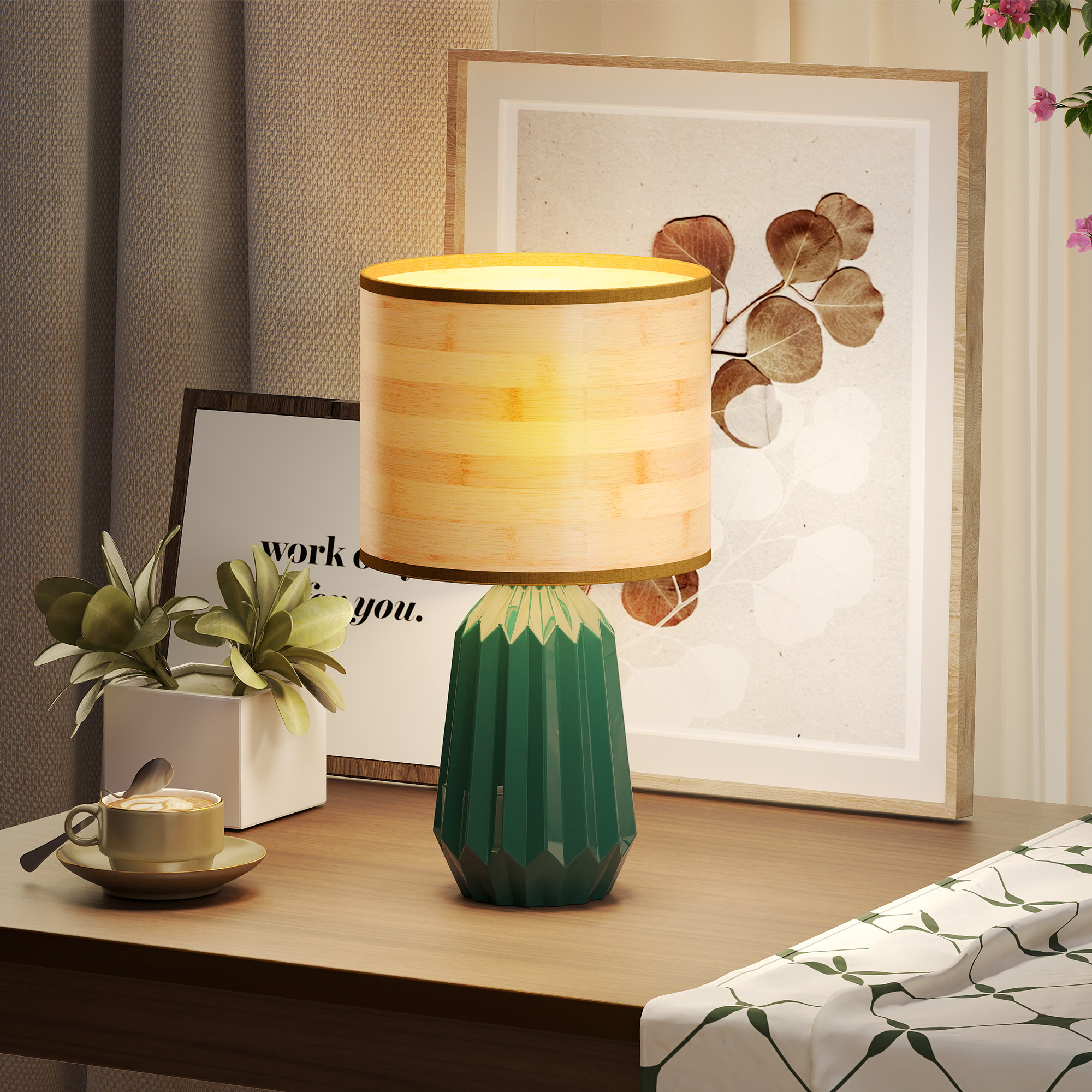 Una base de lámpara verde con pantalla de bambú, junto a un cuadro y una taza de café.