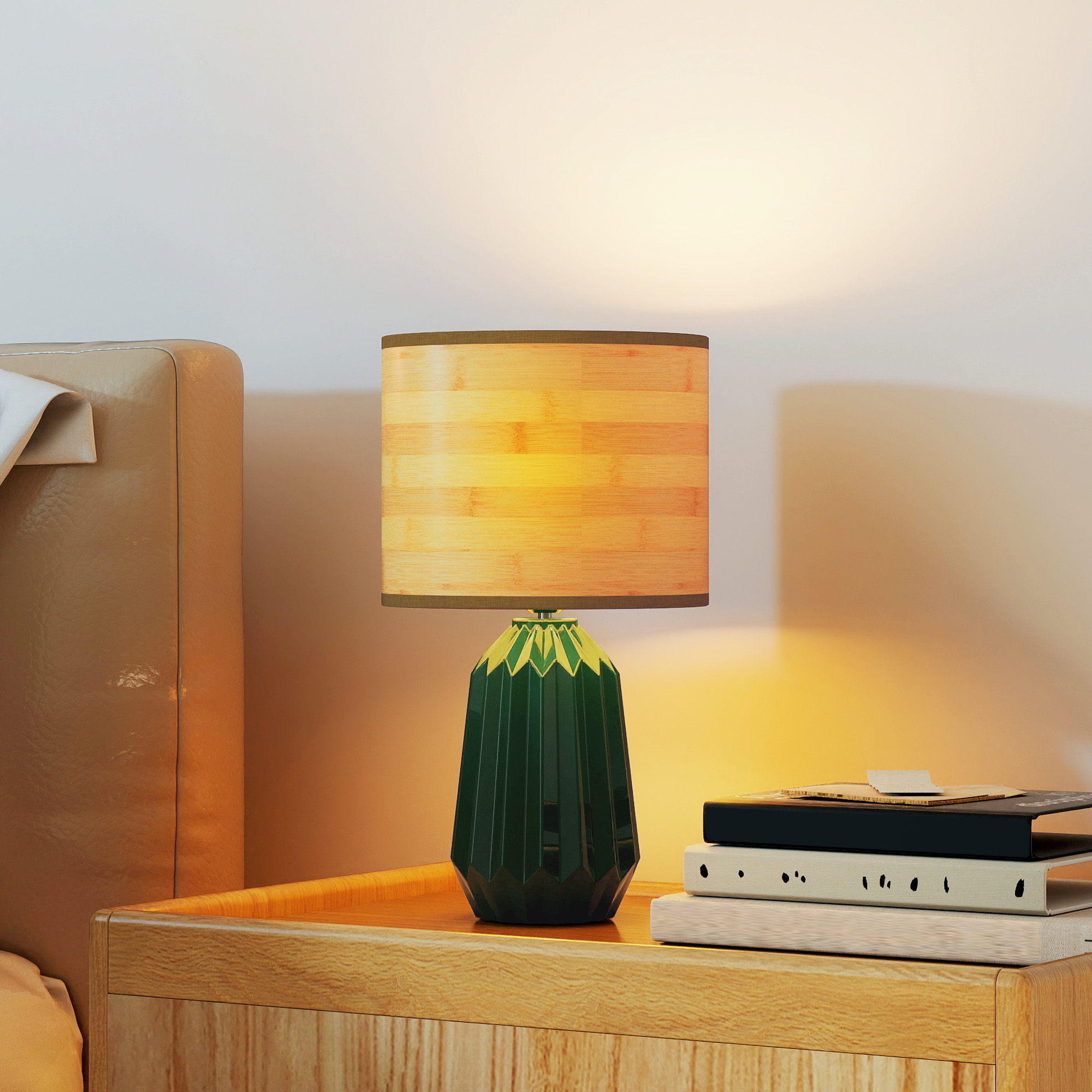 Una mesita de noche de madera con una lámpara verde y libros.