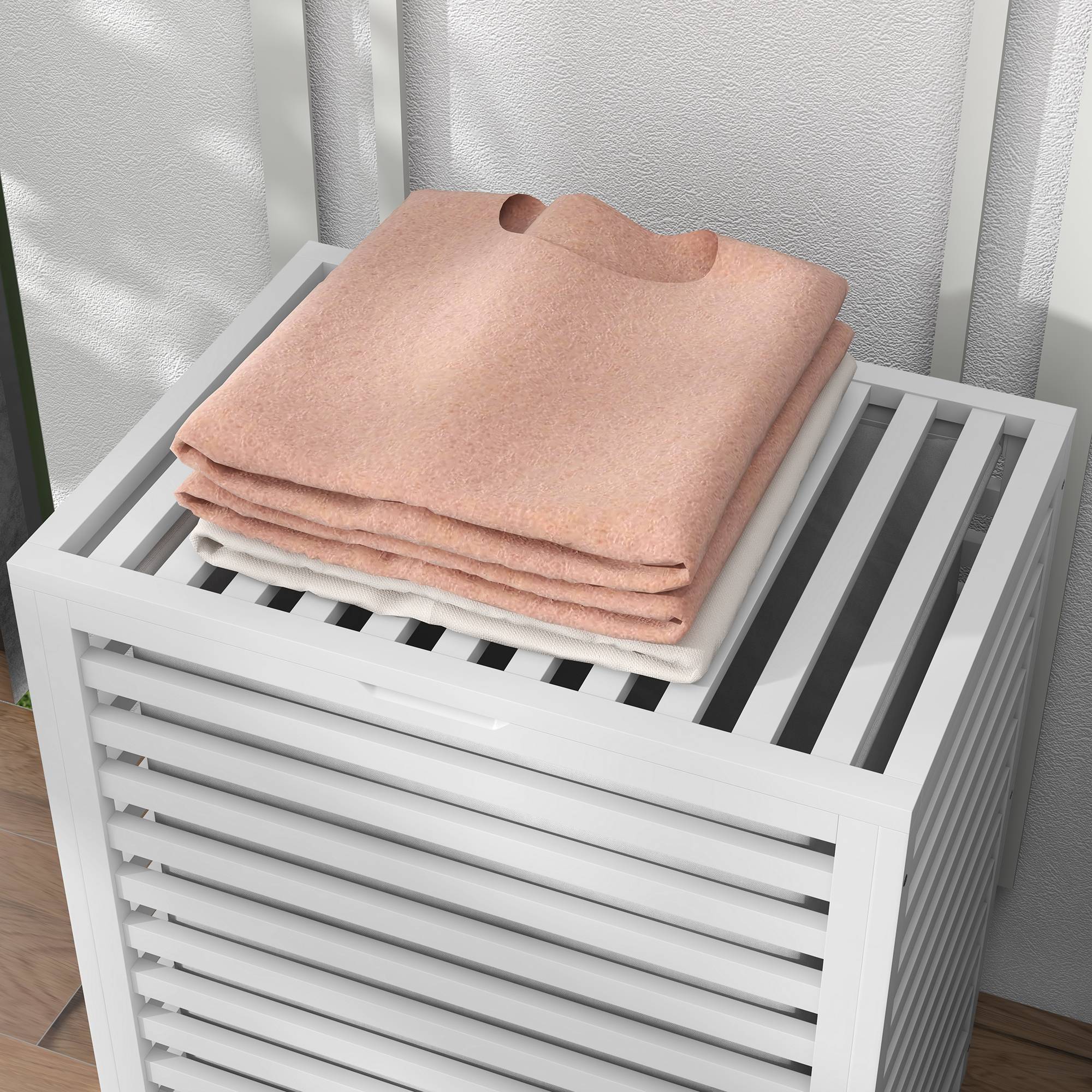 Un suéter color melocotón apilado en una cesta de lavandería blanca con lamas.