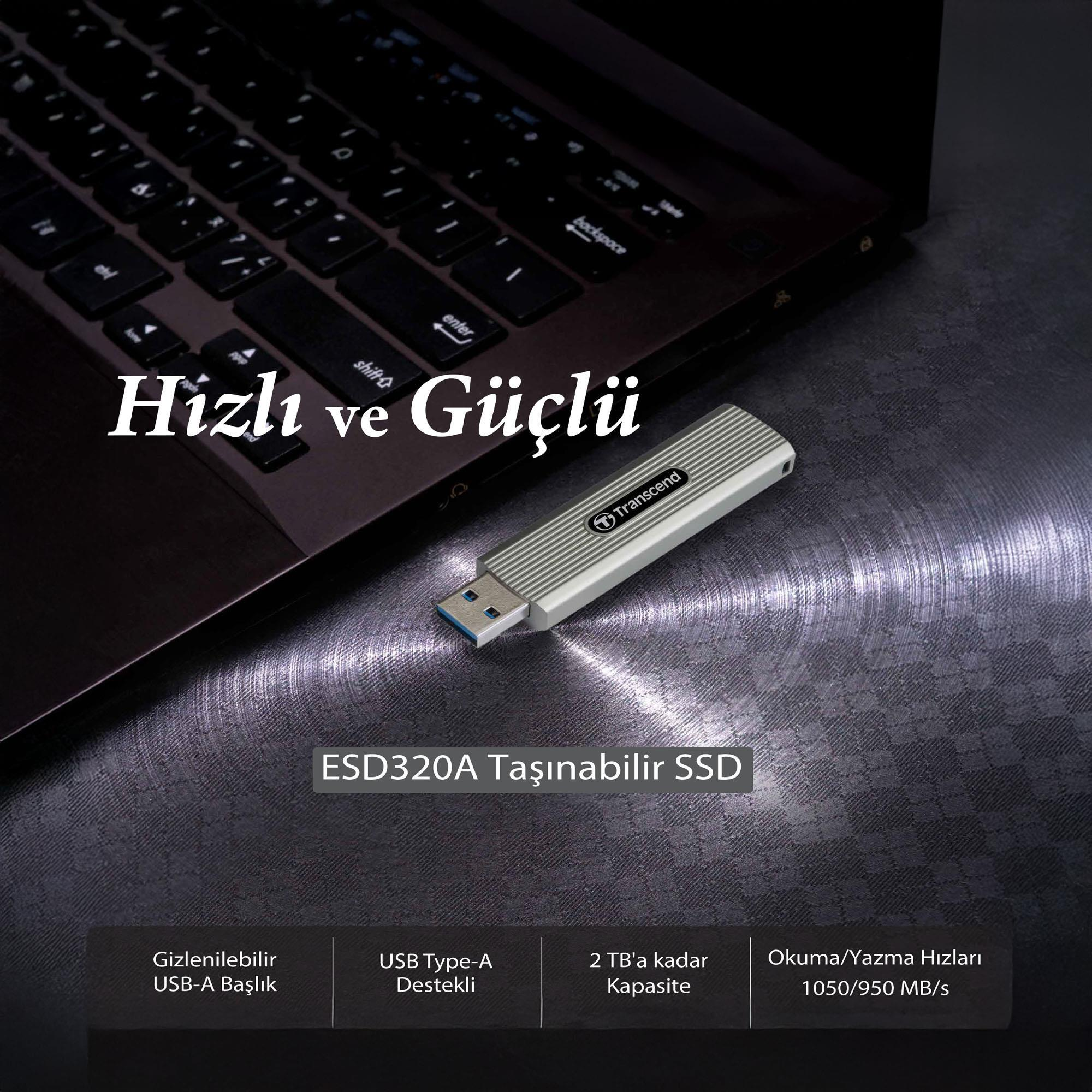 A silver Transcend SSD drive with USB connector rests on a keyboard.