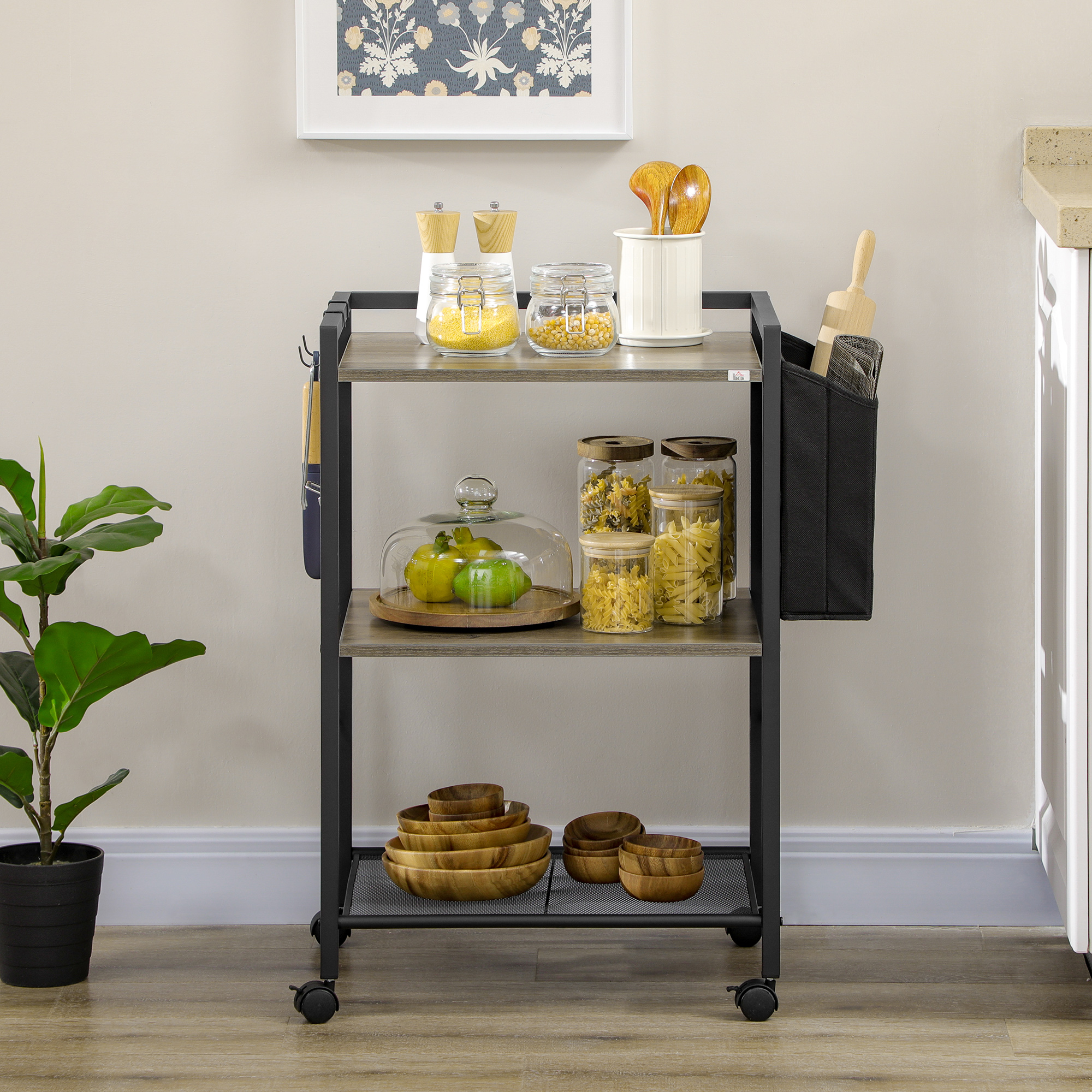 Un carrito de cocina de tres niveles con comida, frascos de vidrio, cuencos de madera y una planta.