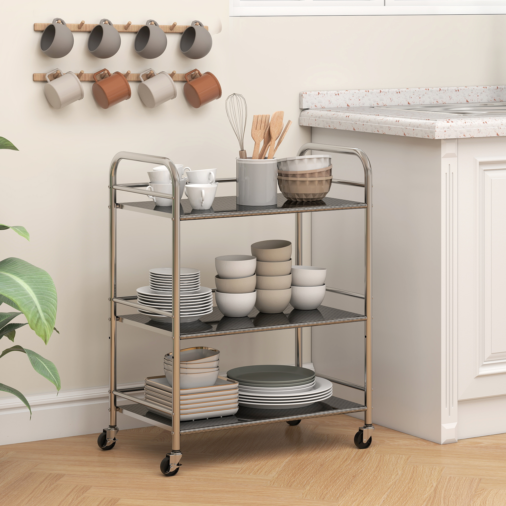 Un carrito de cocina plateado con platos, tazas y utensilios.