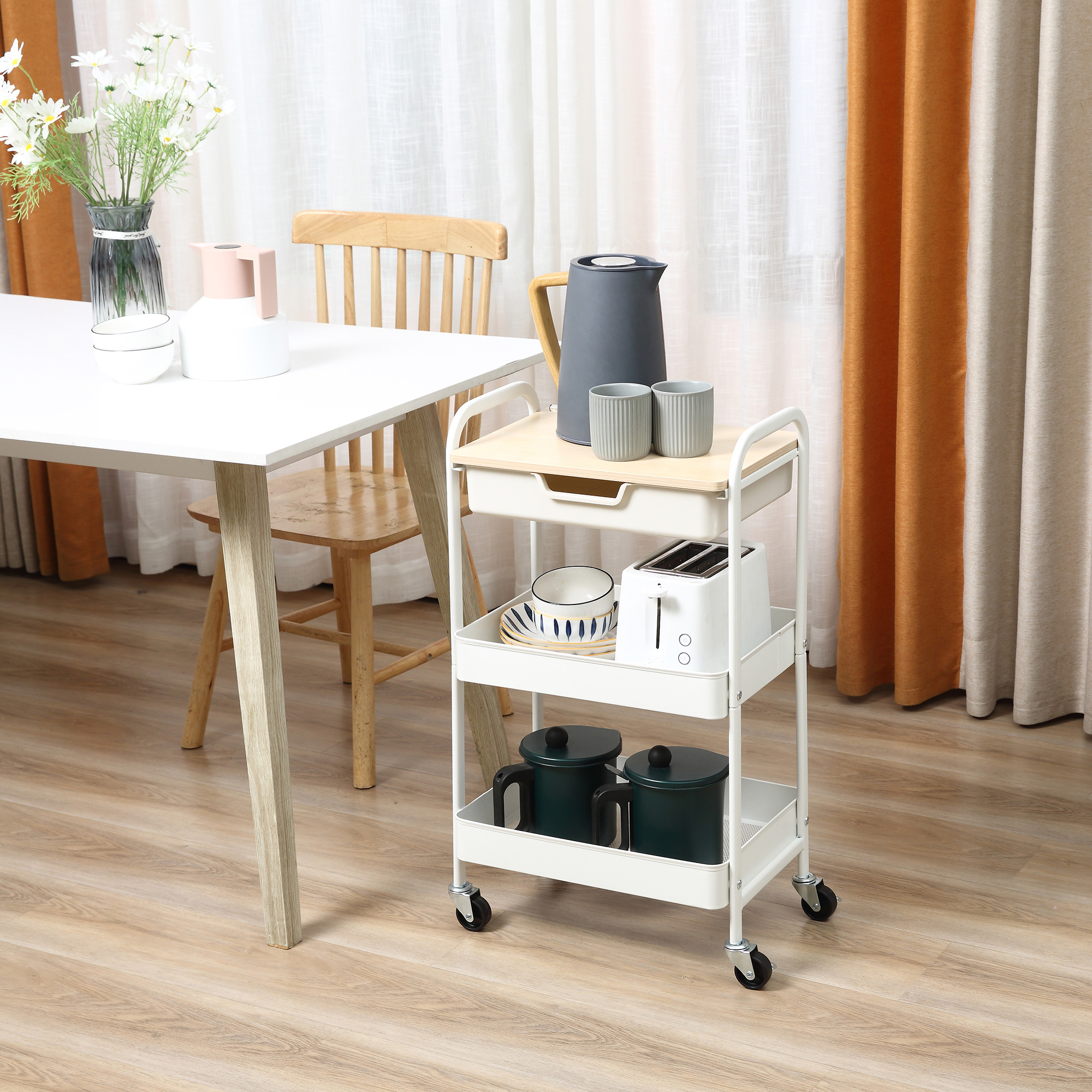 Un carrito de cocina blanco con utensilios junto a una mesa de comedor.