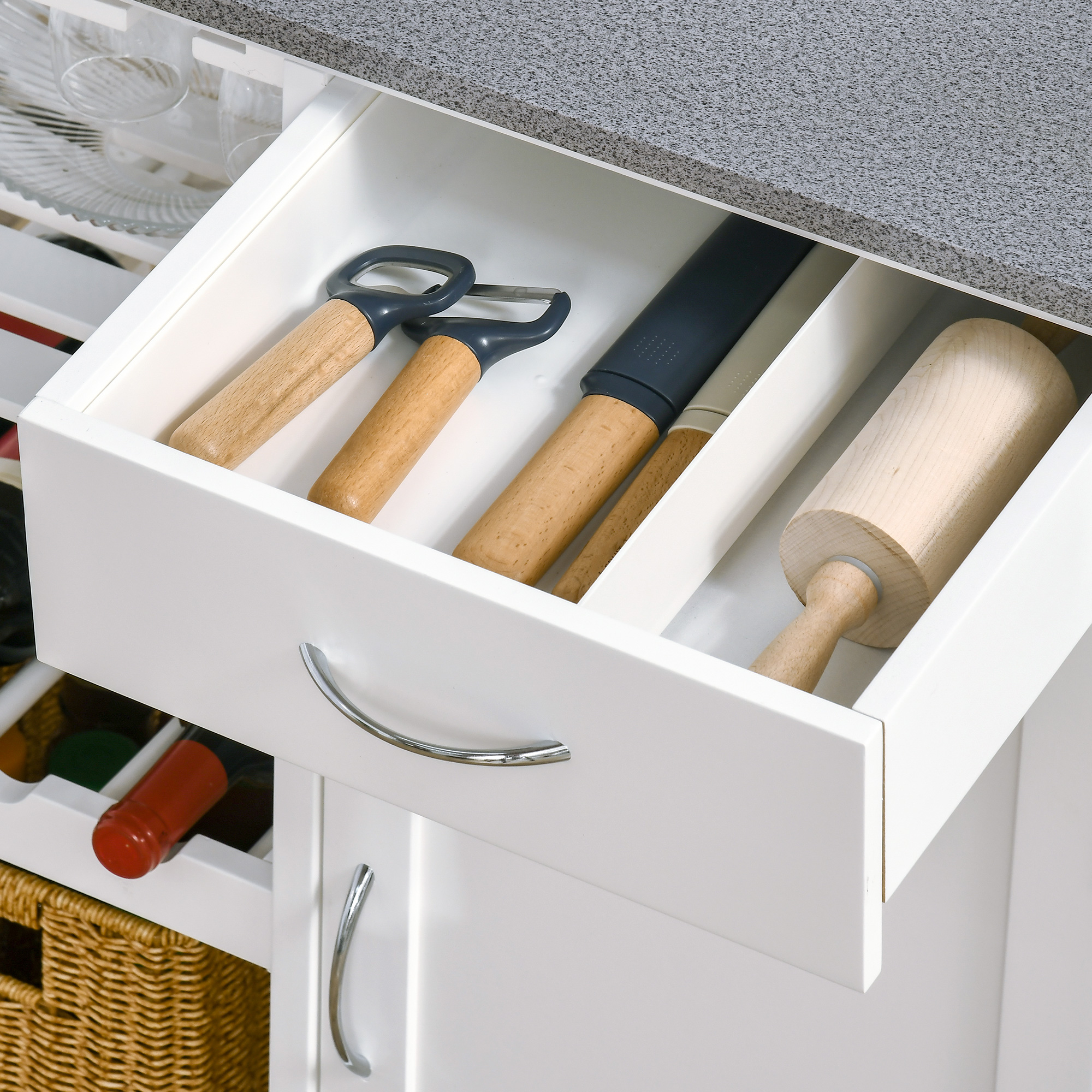 Cajón de cocina abierto con utensilios, incluyendo rodillo y peladores.