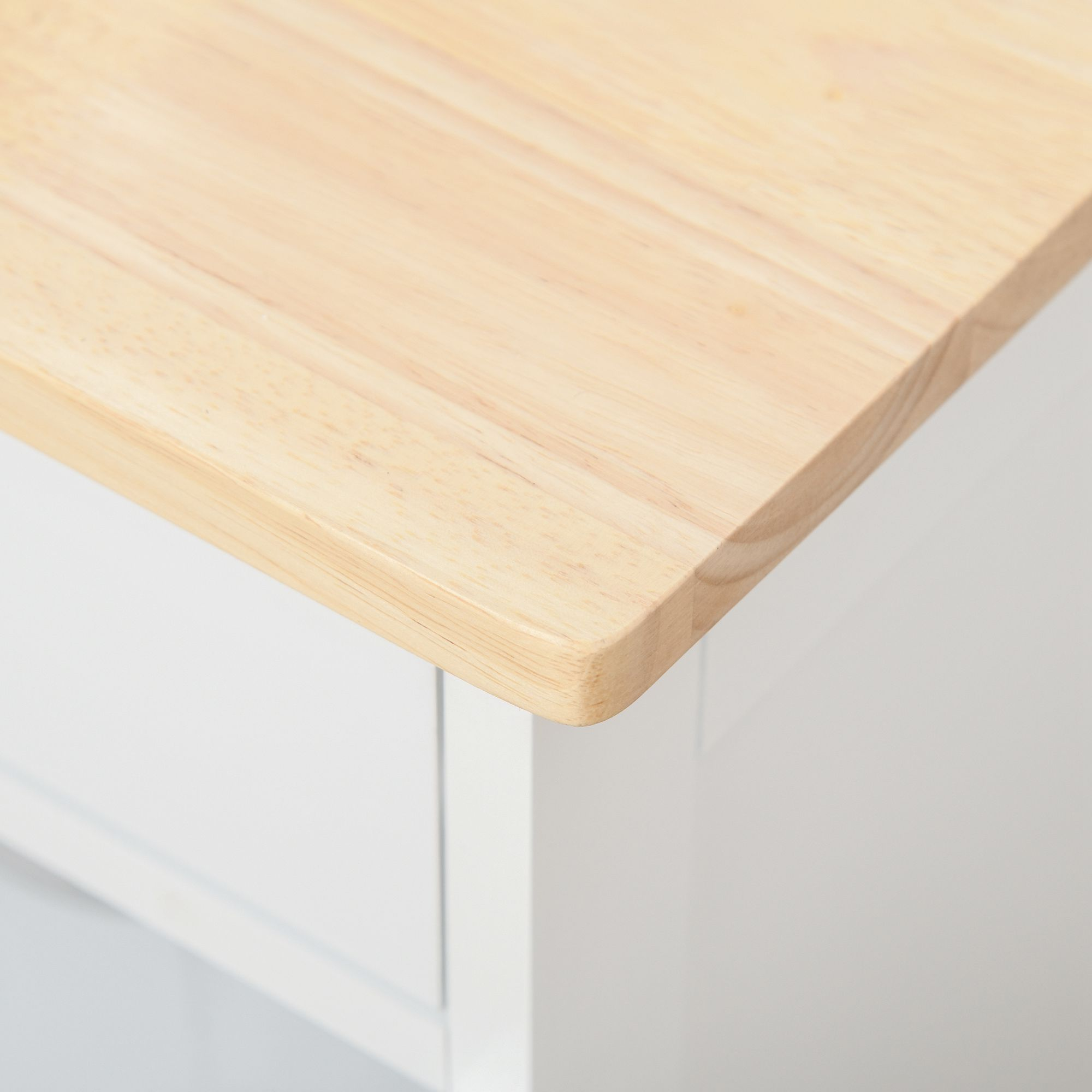 Tablero de madera con esquina redondeada sobre mueble blanco.