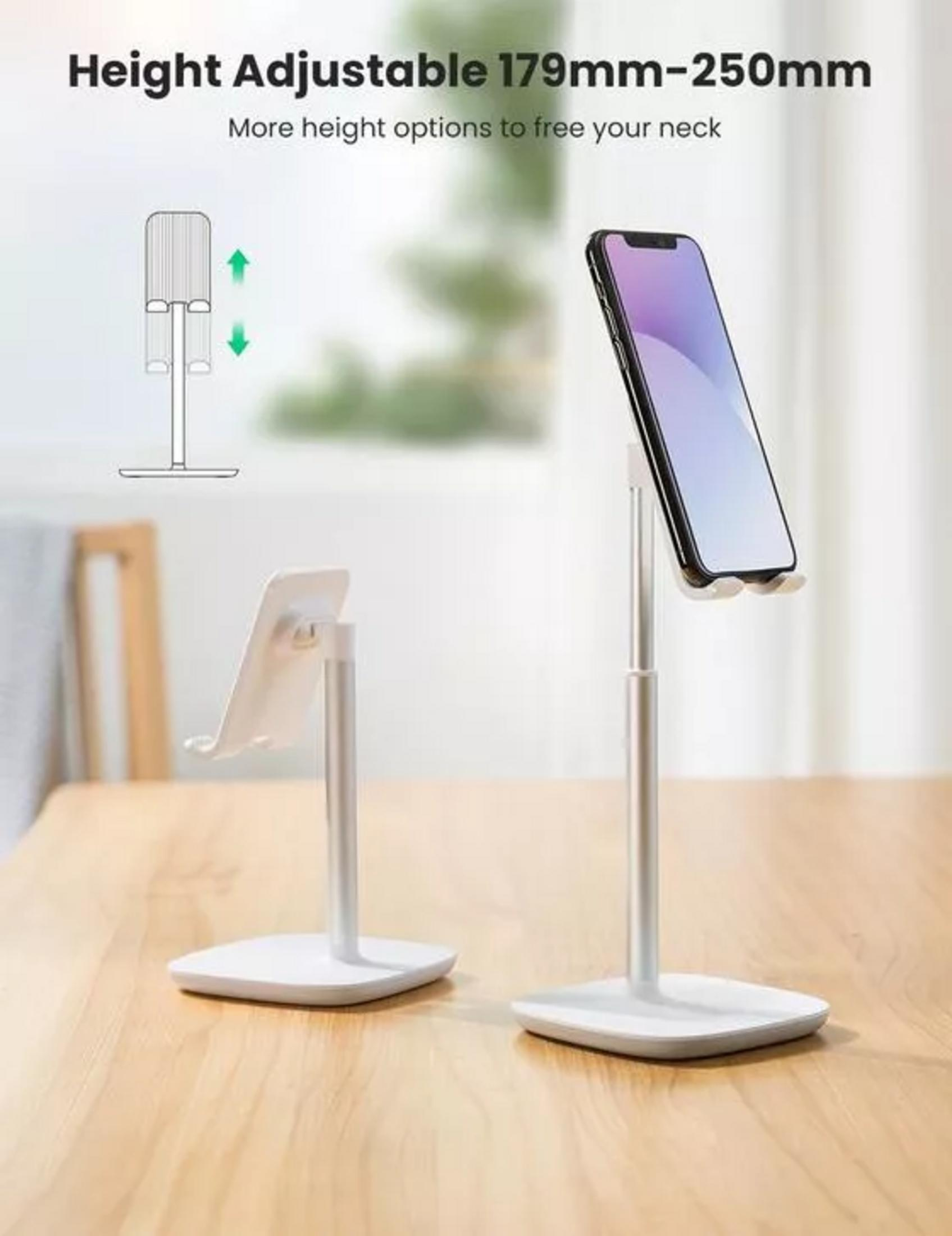 Srebrny uchwyt na telefon z telefonem na drewnianym stole.