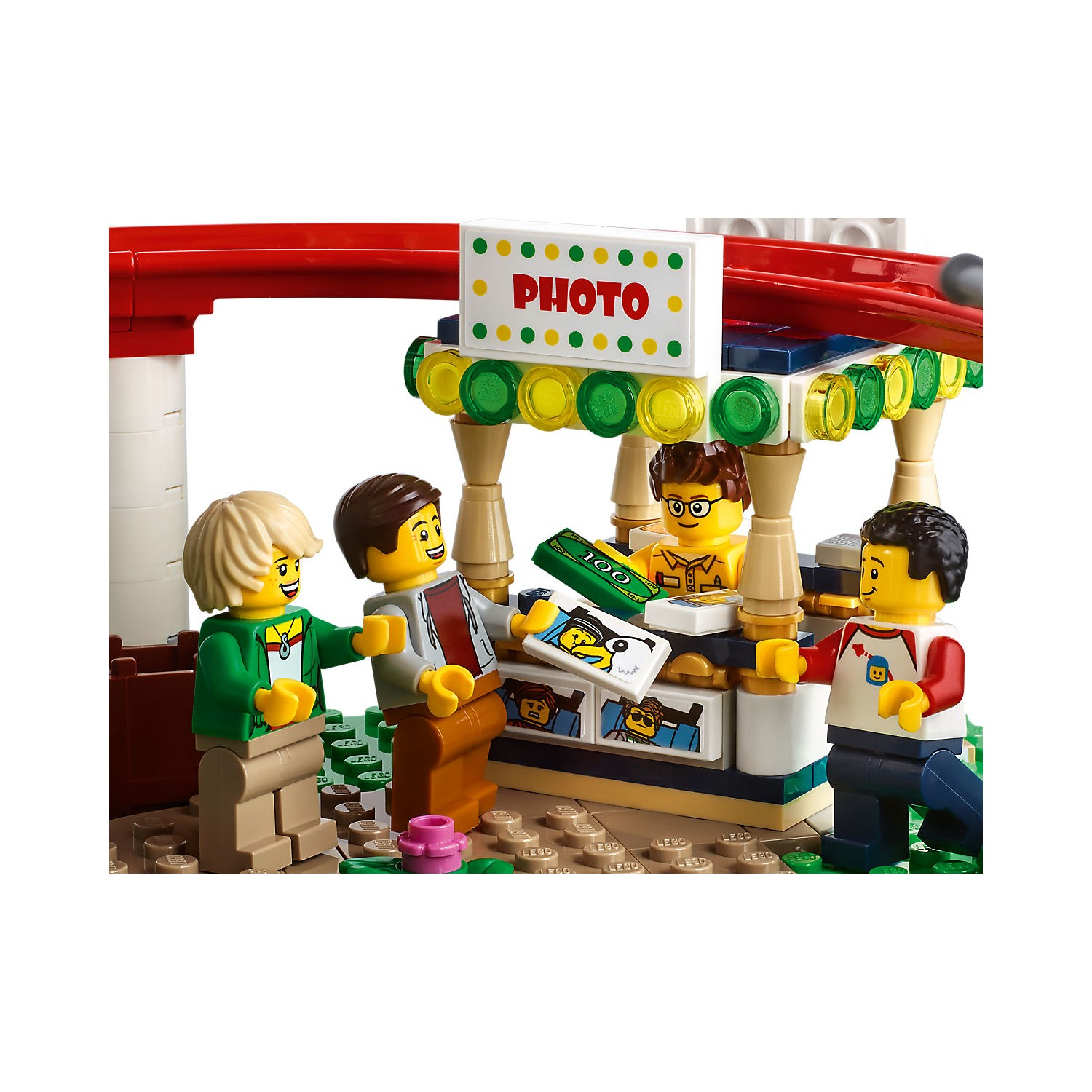 Figurki Lego przy budce ze zdjęciami z tabliczką i pieniędzmi.