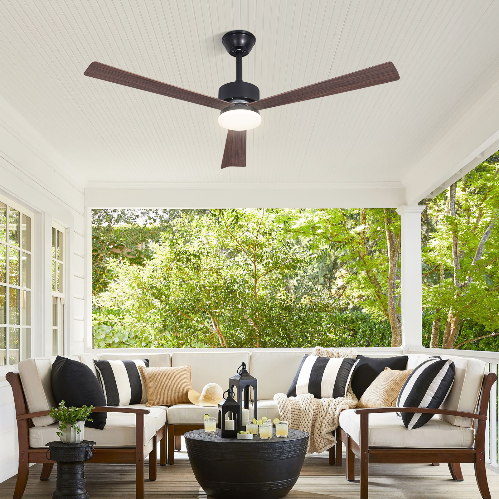 Un portico coperto con sedute, cuscini e ventilatore a soffitto.