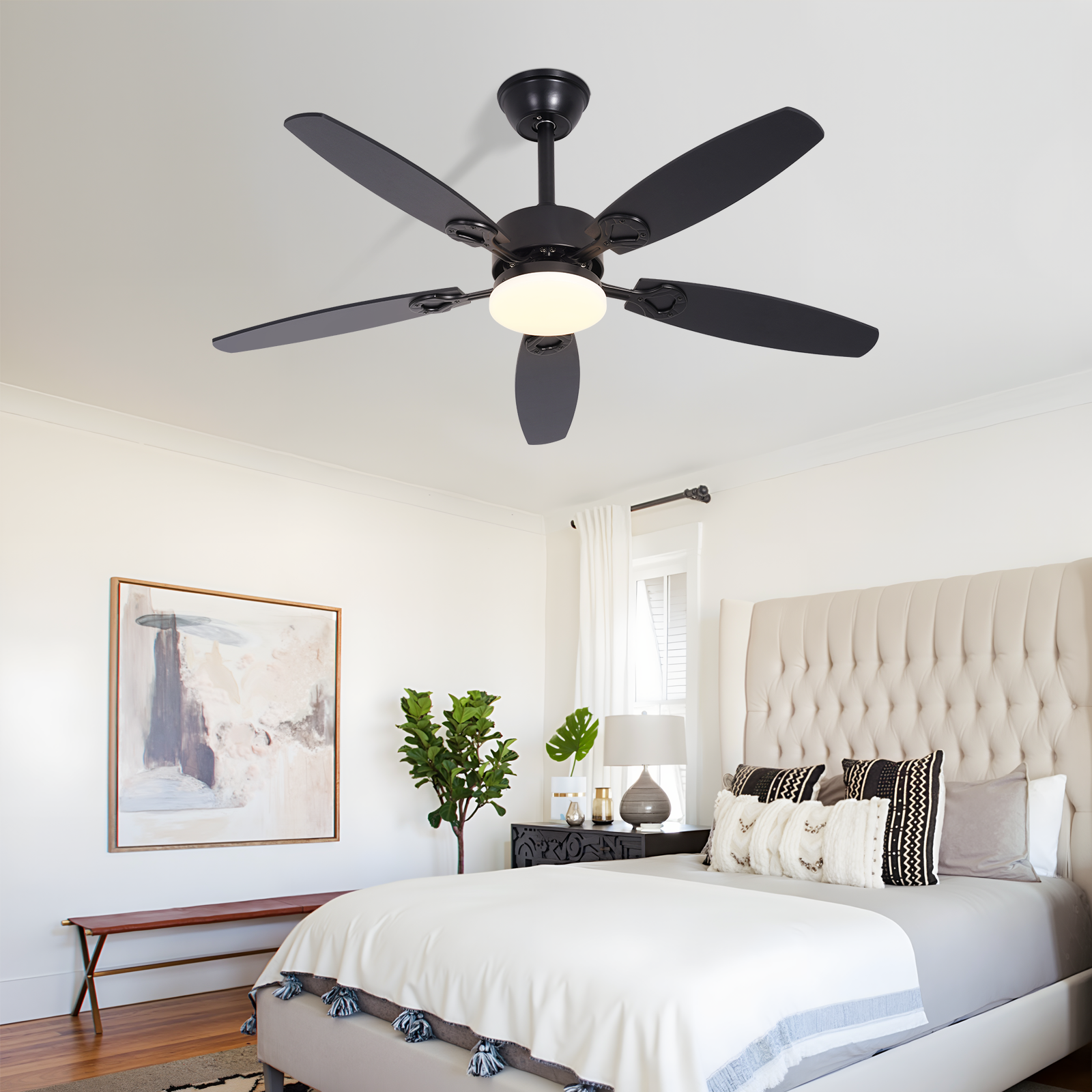 Un ventilatore da soffitto nero con luce sopra un letto in una camera da letto.