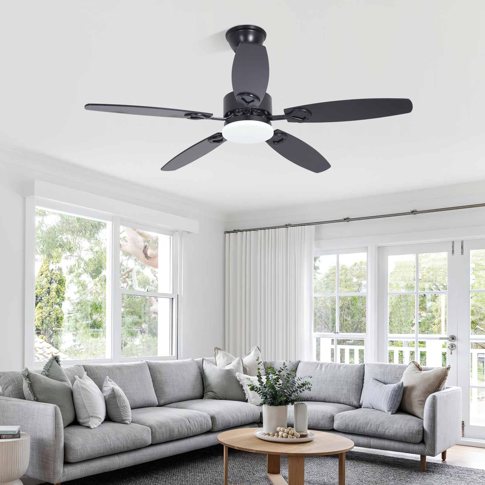Ventilatore da soffitto nero con luce sopra un divano angolare grigio.