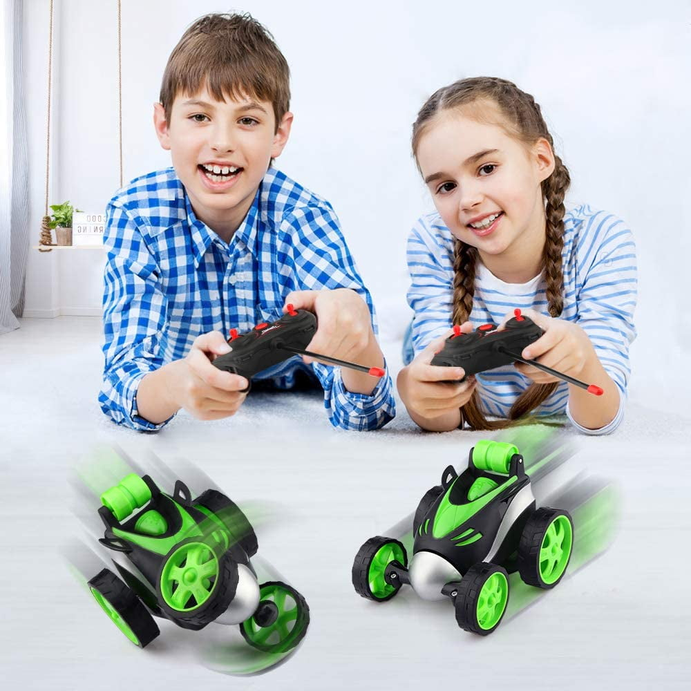 Zwei Kinder liegen auf dem Boden und steuern ferngesteuerte Autos.