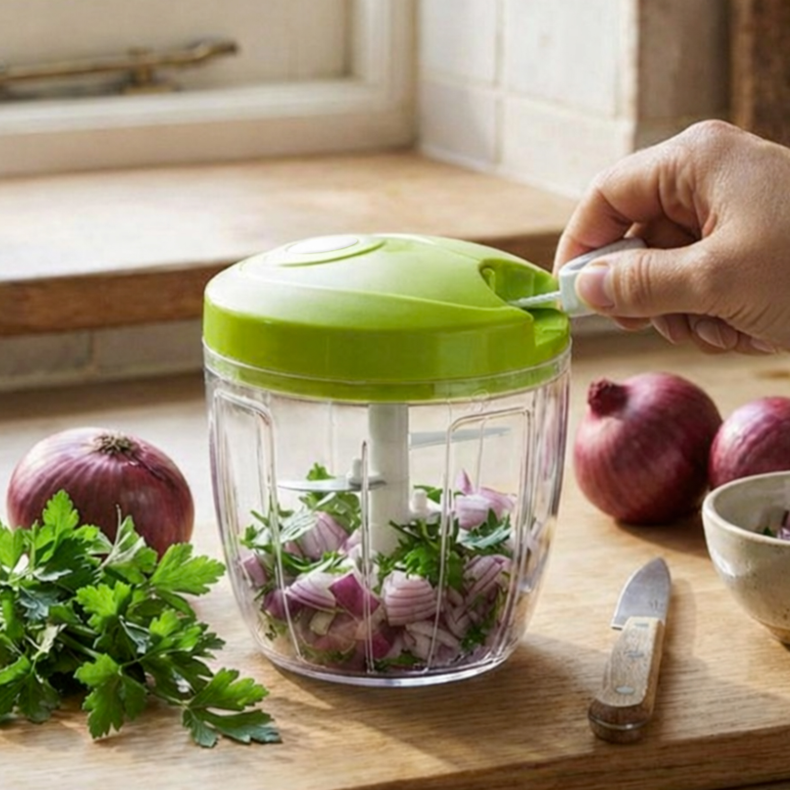 Un tritatutto manuale verde con cipolla e prezzemolo tritati.