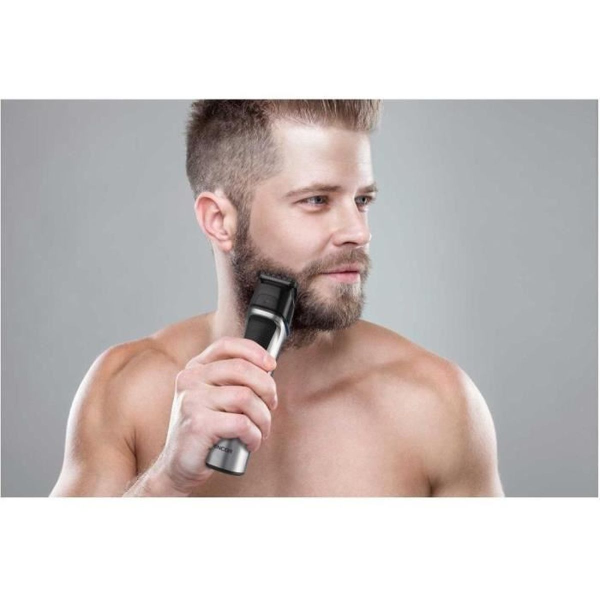 Un uomo con la barba si rade la barba con un tagliacapelli elettrico.