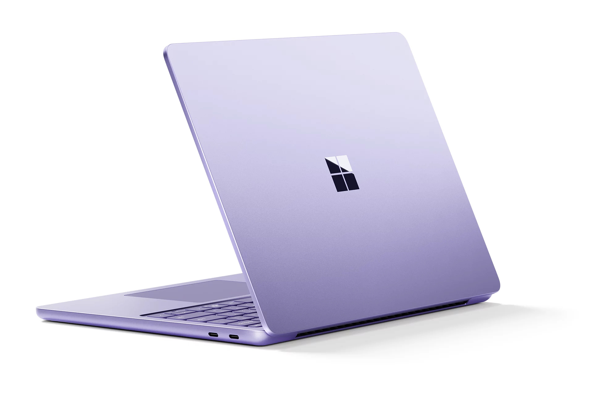 Fioletowy laptop z logo Microsoft na zamkniętej pokrywie, na białym tle.