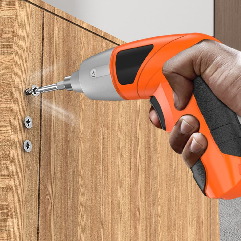 Eine orangefarbene Bohrmaschine schraubt einen silbernen Schraubenkopf in Holz.