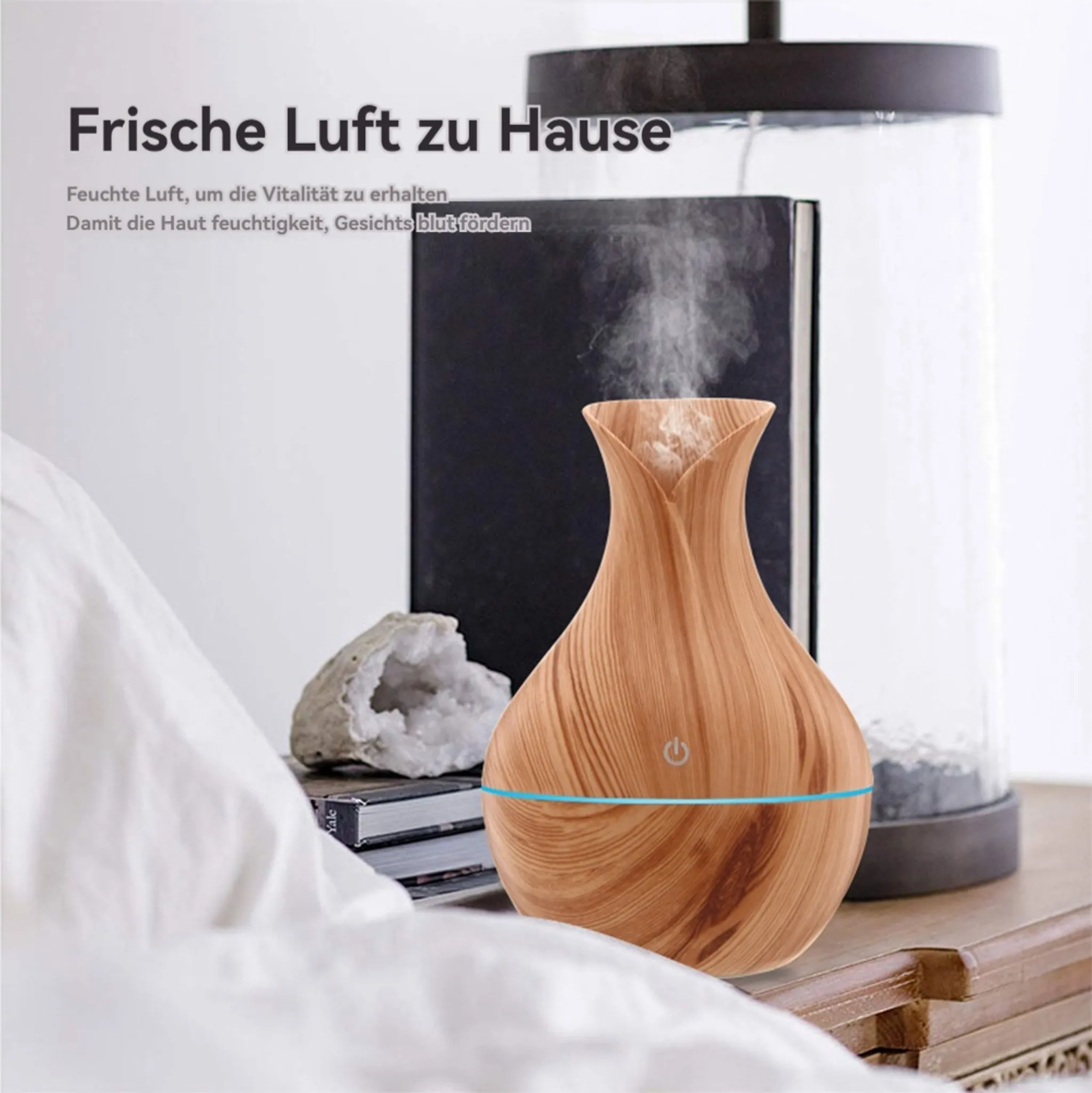 Ein Diffusor mit Holzmaserung gibt Dampf ab, daneben ein Buch und ein Stein.