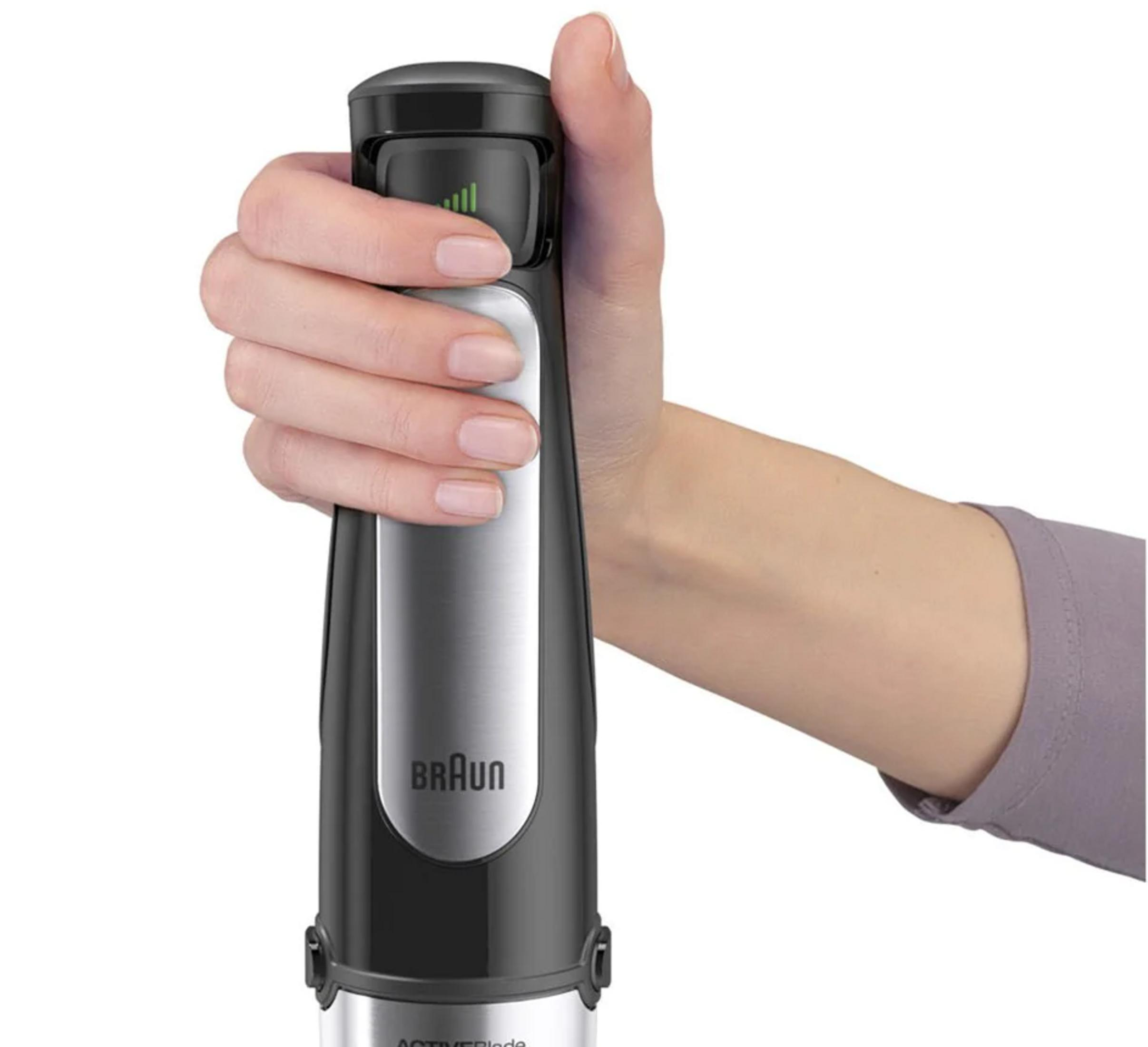 Eine Hand hält einen schwarzen Stabmixer mit silbernen Details und grüner Anzeige.