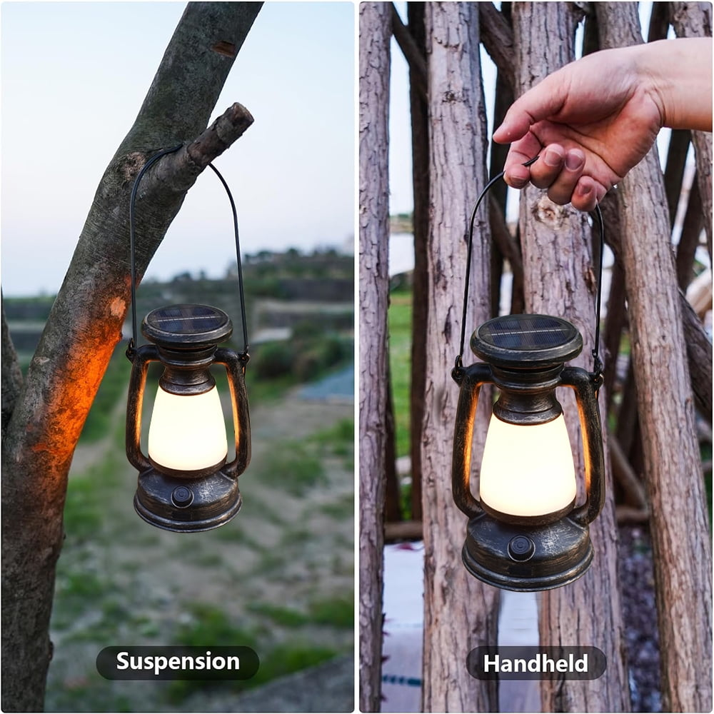 Eine Lampe hängt an einem Baum, eine andere wird gehalten. Beide leuchten.