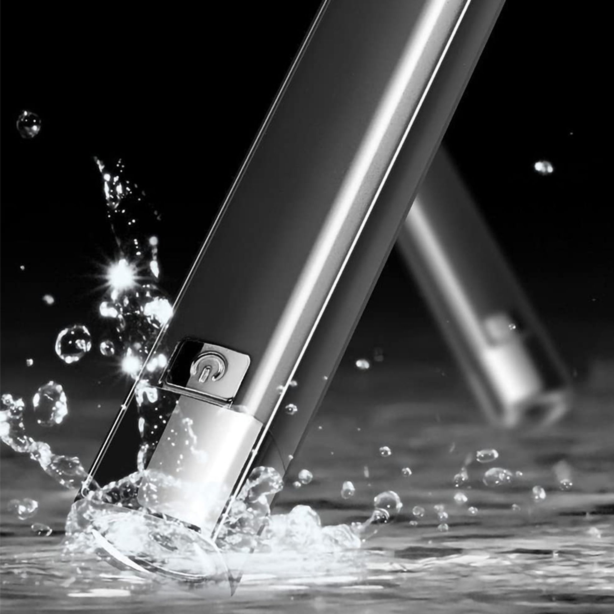 Ein silberner Stab taucht in Wasser, das spritzt und Blasen bildet.