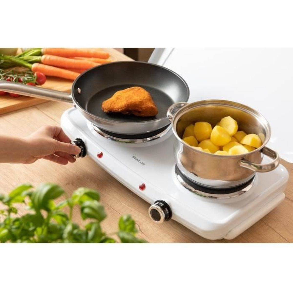 Una persona cucina una cotoletta impanata e patate su un fornello bianco.