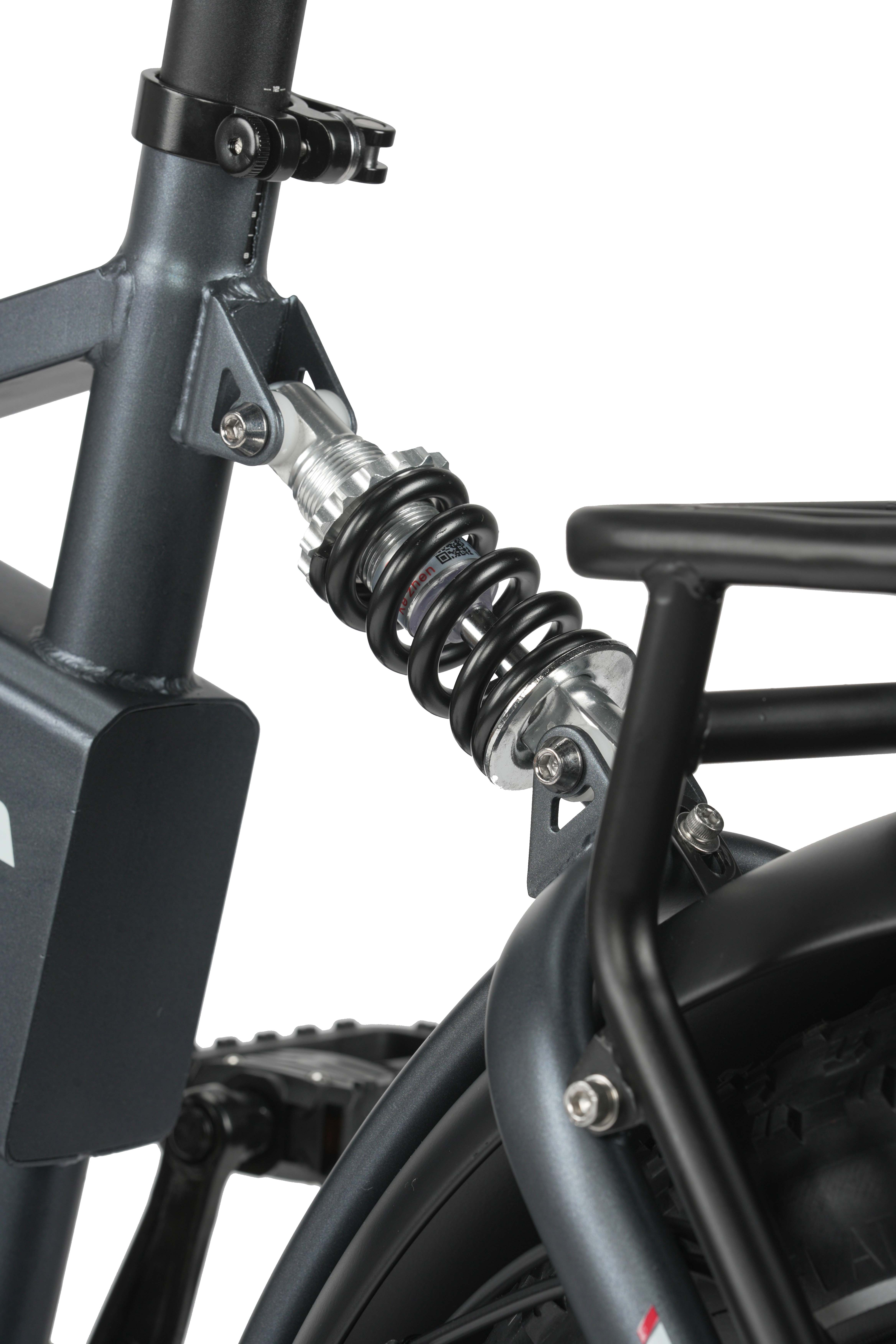 Primo piano del telaio grigio della bicicletta con sospensione nera e portapacchi.