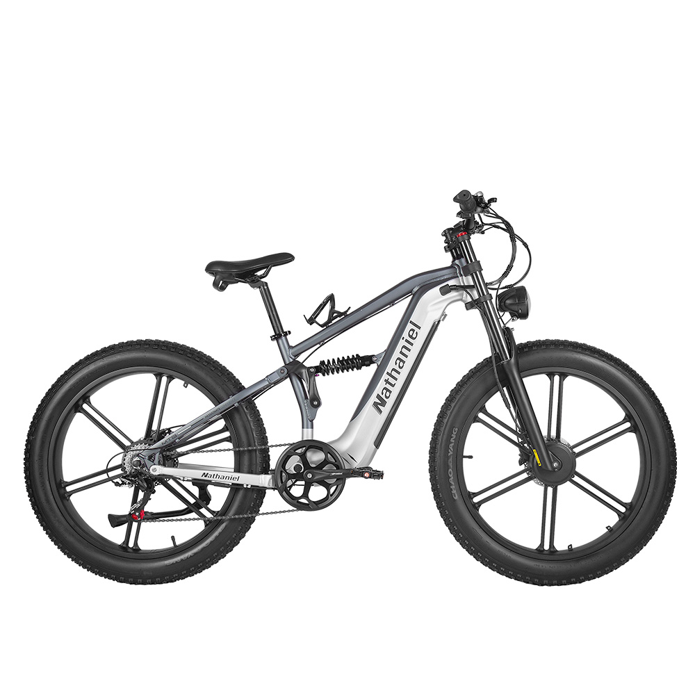 Una bicicleta eléctrica gris y blanca con ruedas anchas y suspensión sobre fondo blanco.