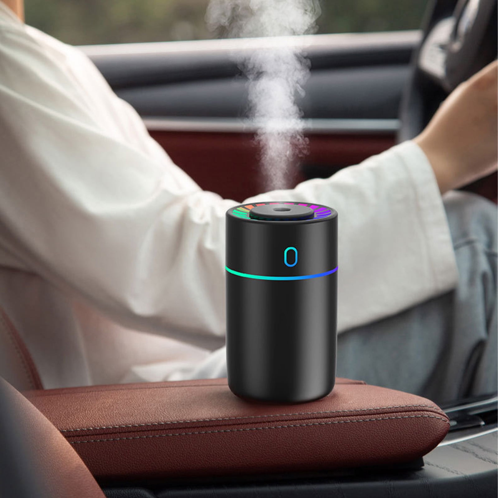 Ein schwarzer Luftbefeuchter im Auto gibt Dampf ab, mit bunten Lichtern.