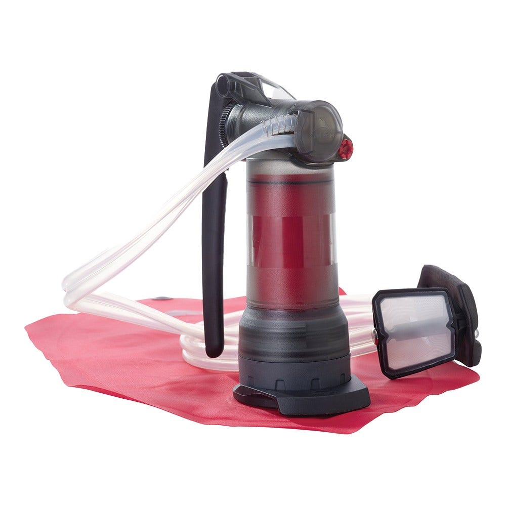 Ein roter Wasserfilter mit Schläuchen auf einer roten Matte.