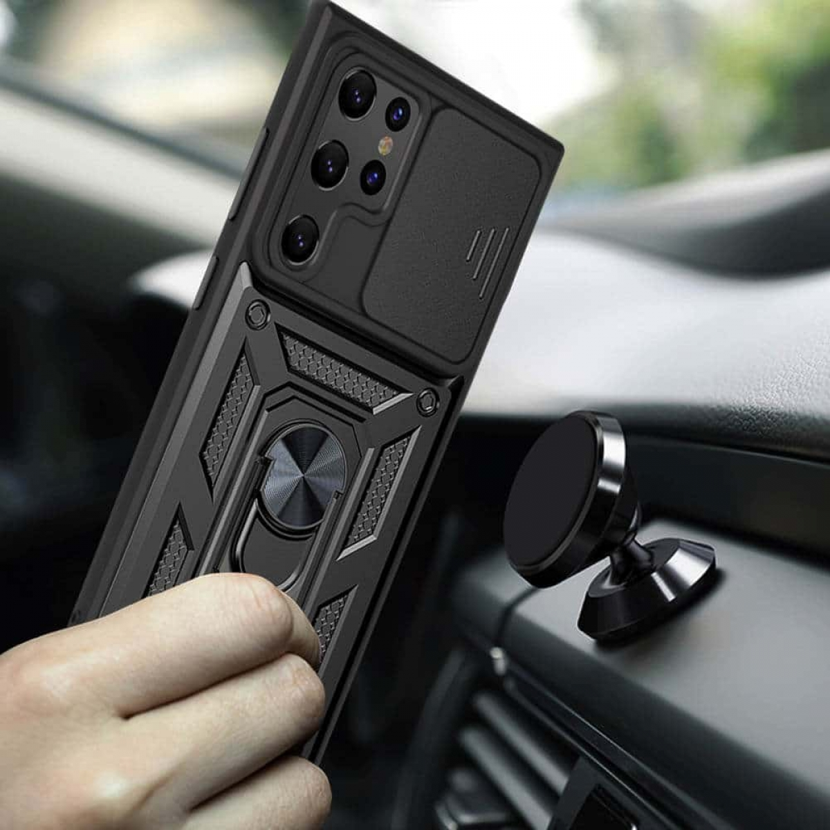 Schwarze Handyhülle mit Ringhalter und Schiebefach vor Autoinnenraum.
