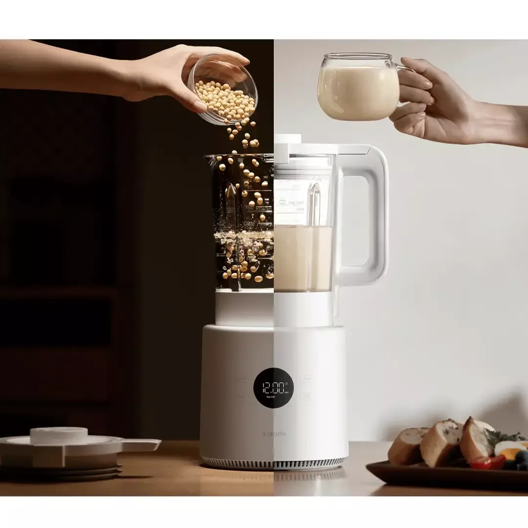 Una mano versa soia in un frullatore. Un bicchiere di latte di soia.