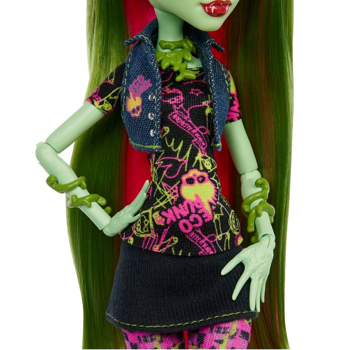 Grüne Puppe mit langen Haaren, die ein schwarzes Shirt, eine blaue Weste und einen schwarzen Rock trägt.