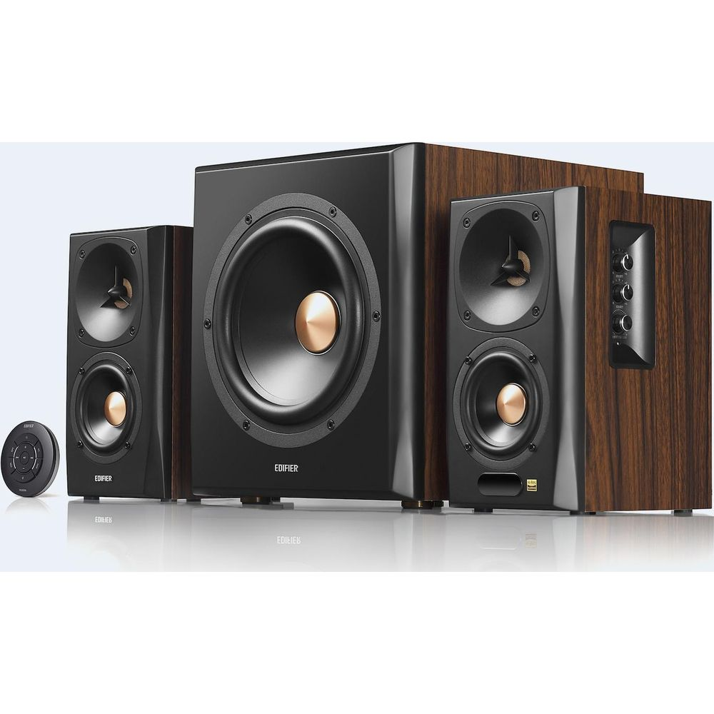 Subwoofer i dwa głośniki z drewnianym wykończeniem oraz pilot zdalnego sterowania.