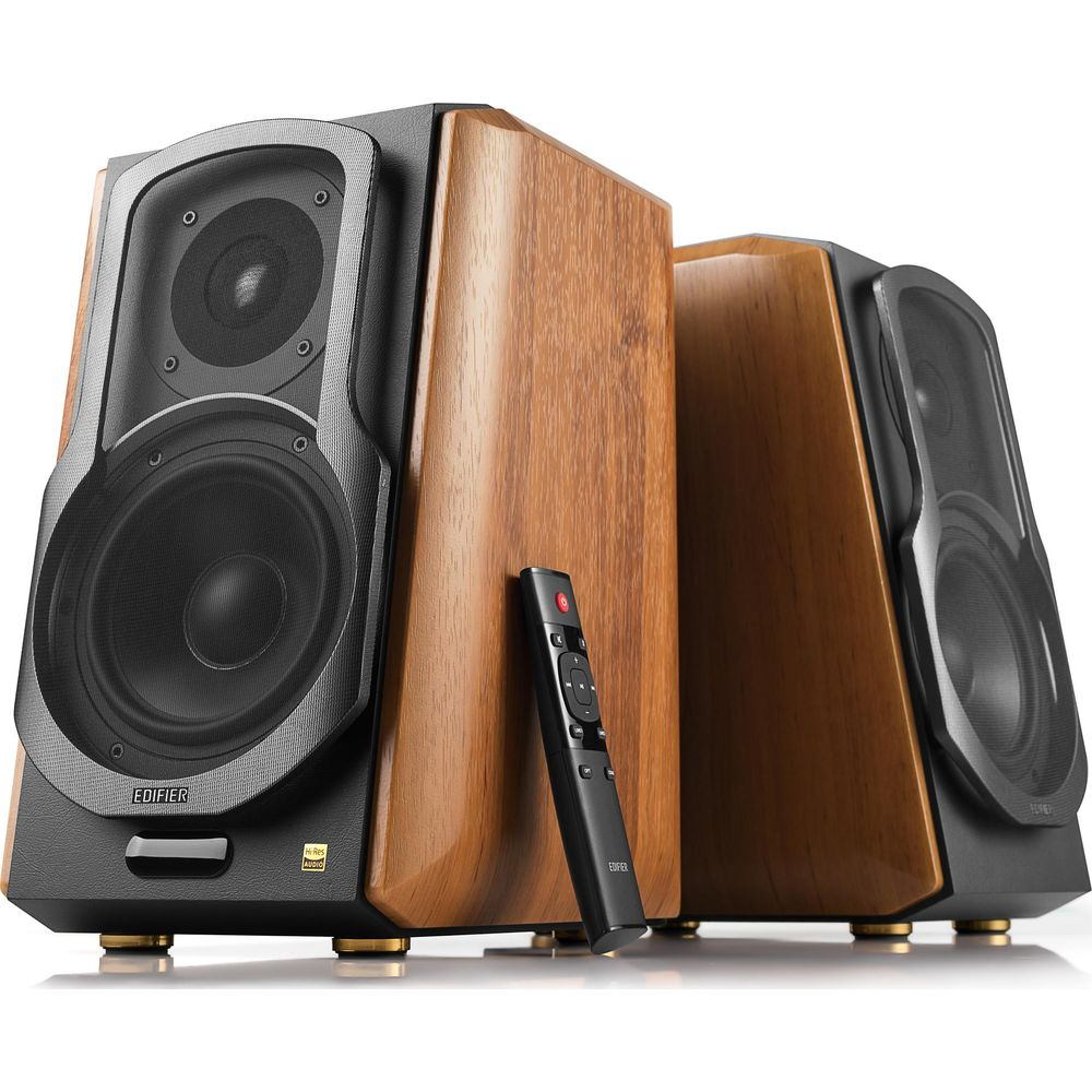 Dwa drewniane głośniki Edifier z pilotem opartym o jeden z nich.