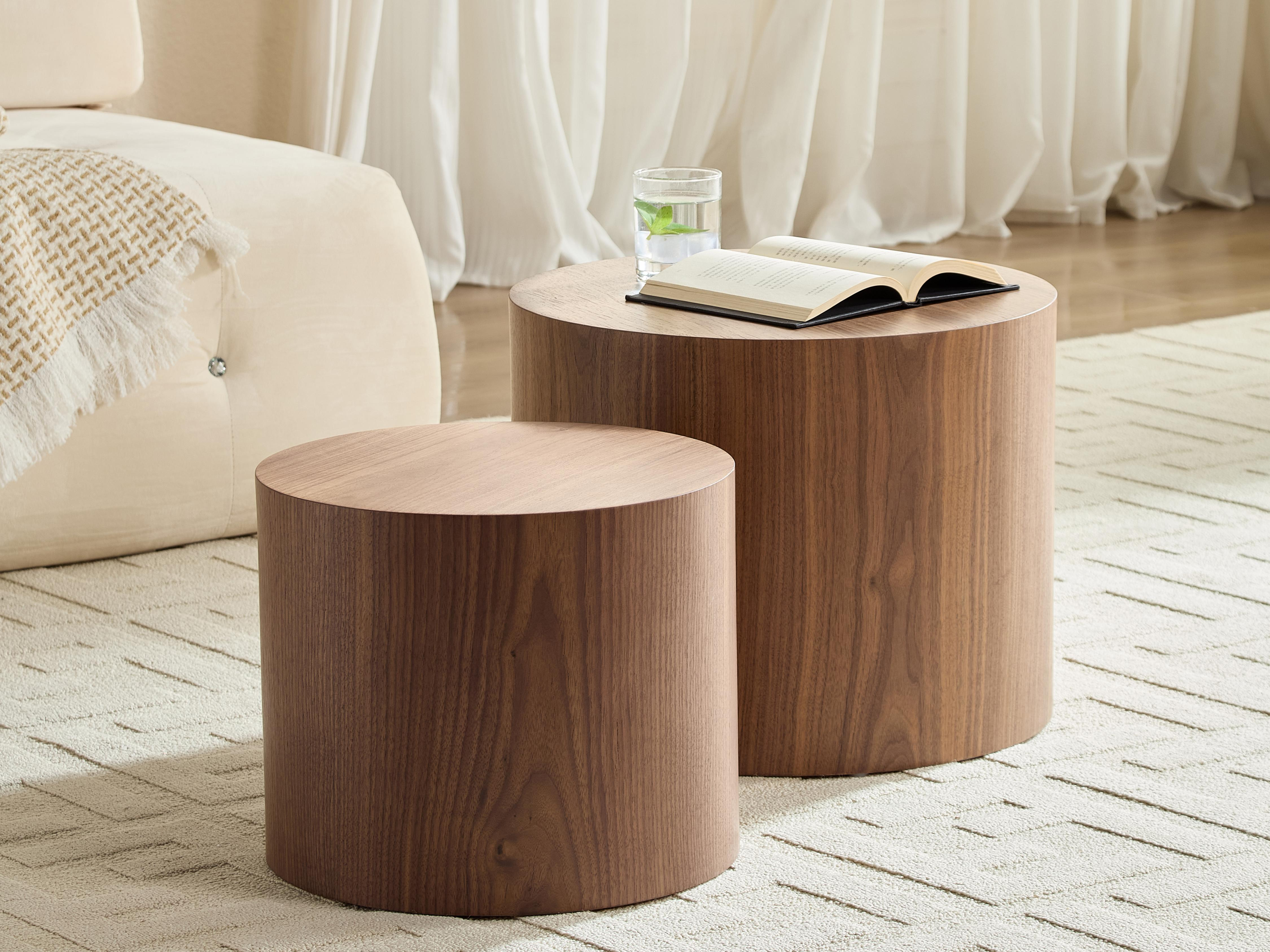 Zwei runde Holztische im Wohnzimmer mit Buch und Wasserglas.