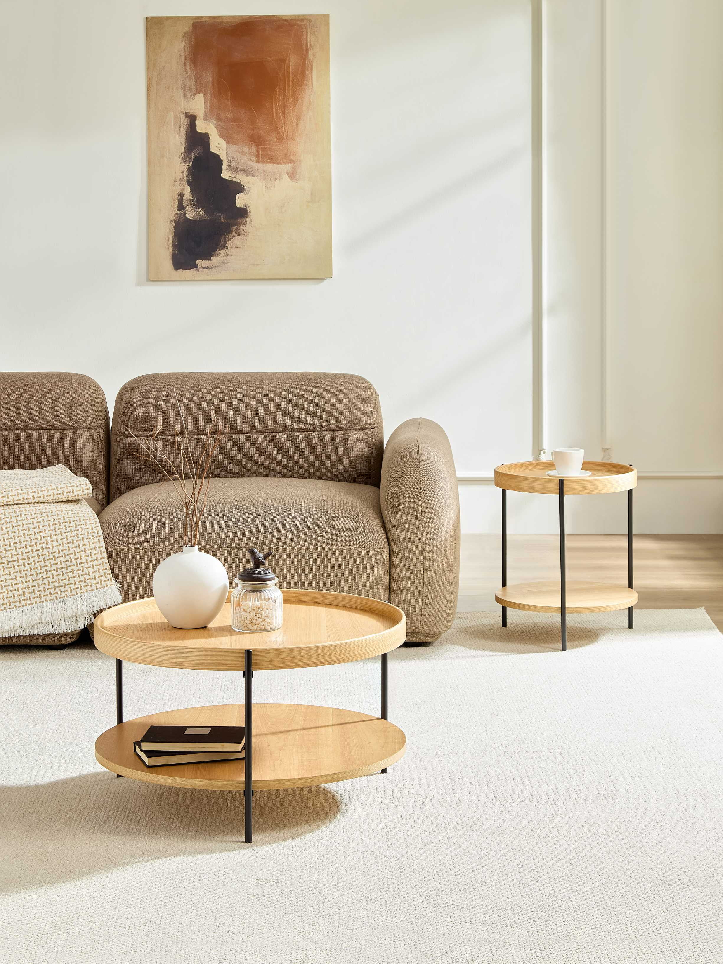 Ein brauner Sofa mit Couchtisch, Beistelltisch und Kunstwerk.