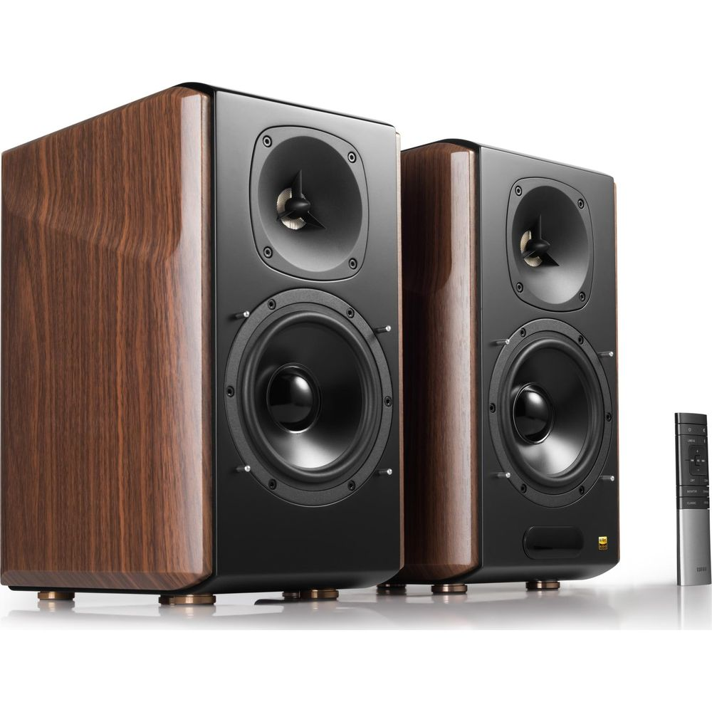 Dwa brązowe i czarne głośniki z pilotem.