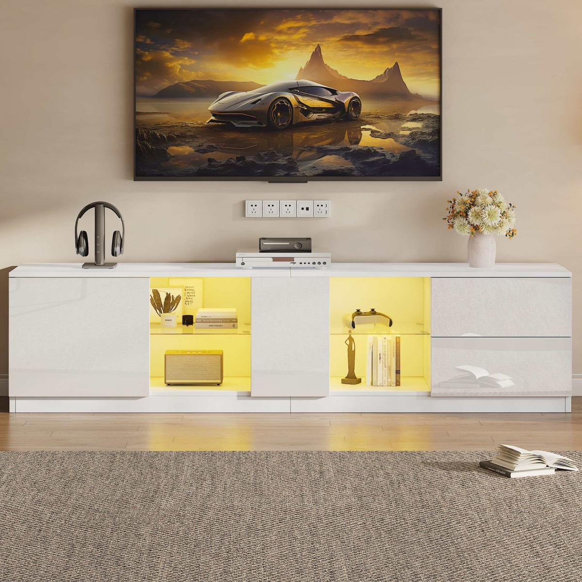 Ein moderner weißer Fernsehschrank mit gelben Lichtern. Ein Auto auf einem Berg im Fernsehen.