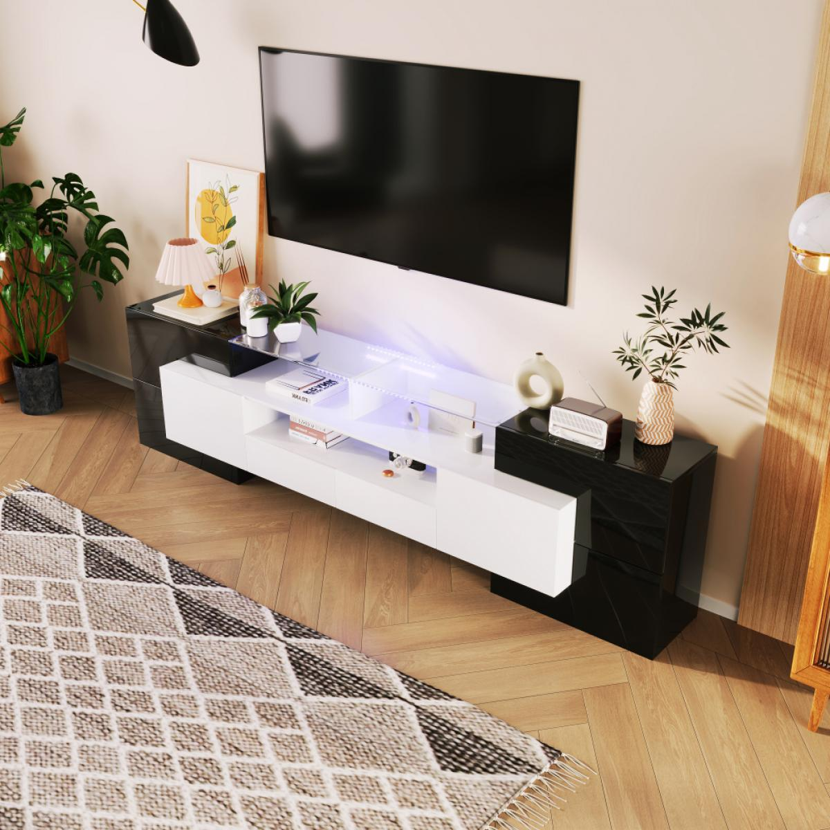Ein modernes Wohnzimmer mit einem schwarz-weißen TV-Ständer, großem Fernseher, Pflanzen und Teppich.