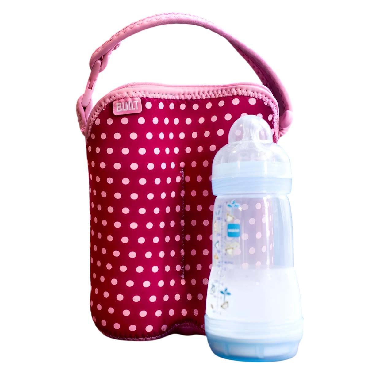 Eine pinke Flaschenhülle mit weißen Punkten steht neben einer Babyflasche.