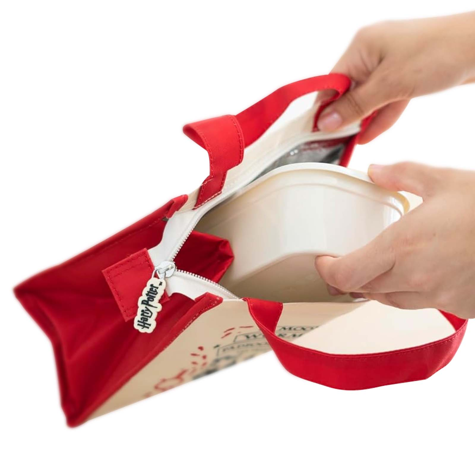 Eine rote Harry Potter Tasche mit Reißverschluss, in die ein weißer Behälter gelegt wird.