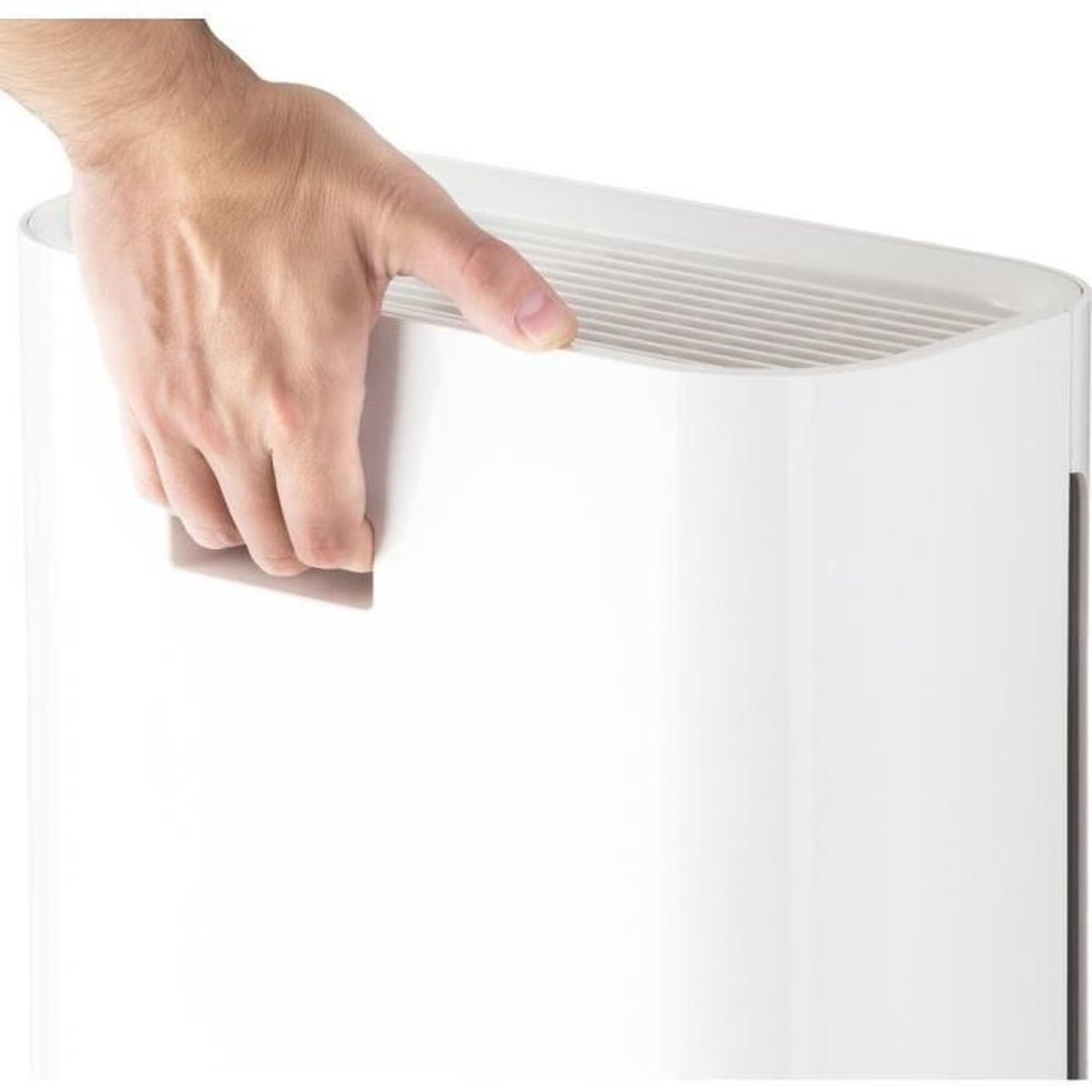 Una mano afferra la maniglia di un dispositivo bianco con fessure di ventilazione.