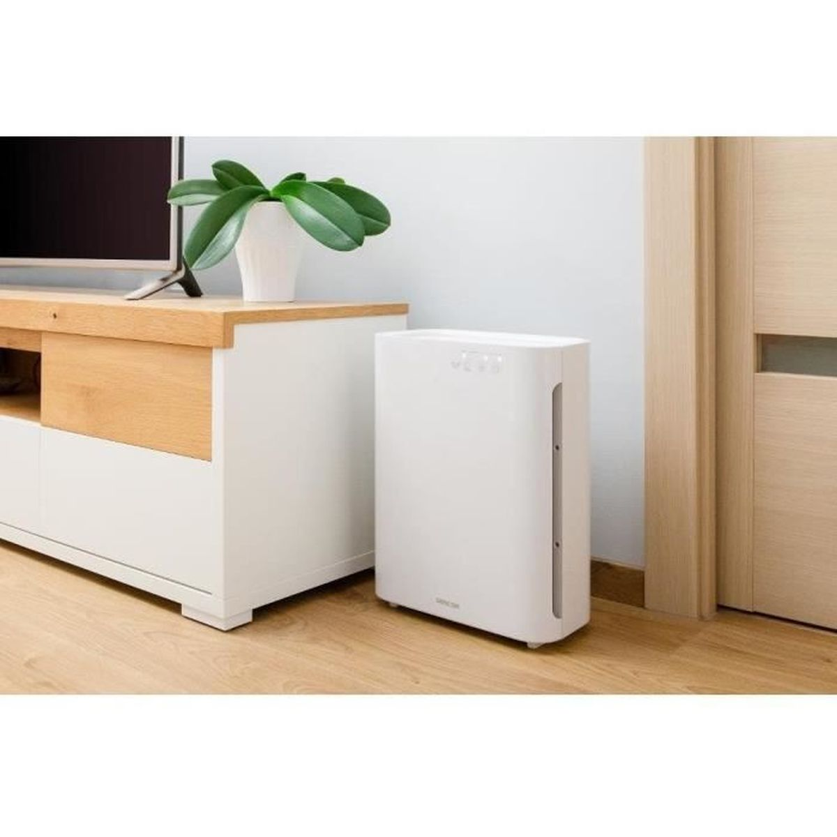 Un purificatore d'aria bianco accanto a un mobile TV bianco con accenti in legno.